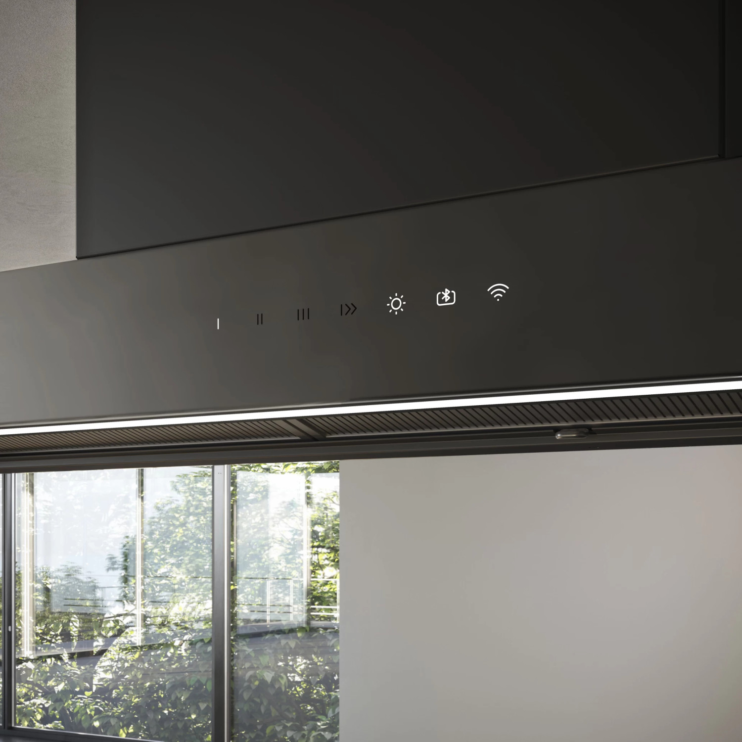 Cappa moderna con comandi touch e luce, vista sul verde attraverso la finestra.