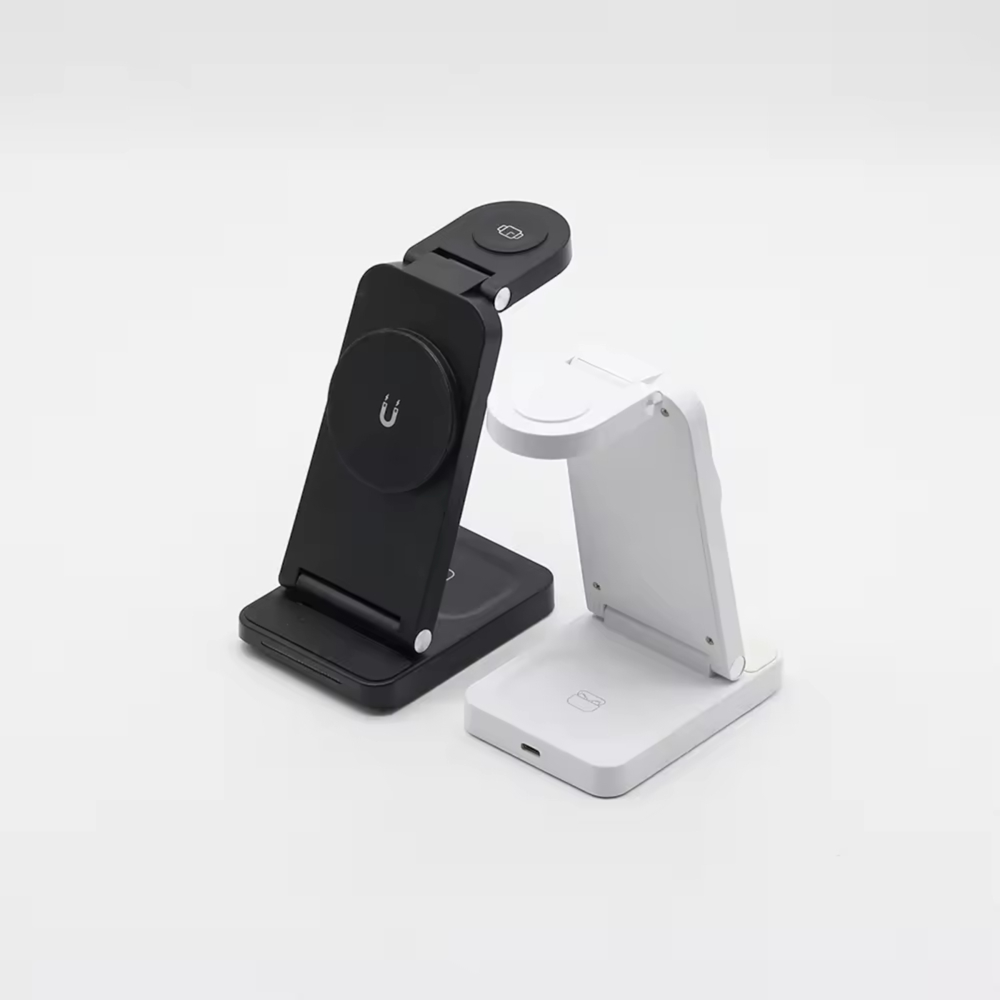 Due caricatori wireless pieghevoli, uno nero, uno bianco, su sfondo bianco.