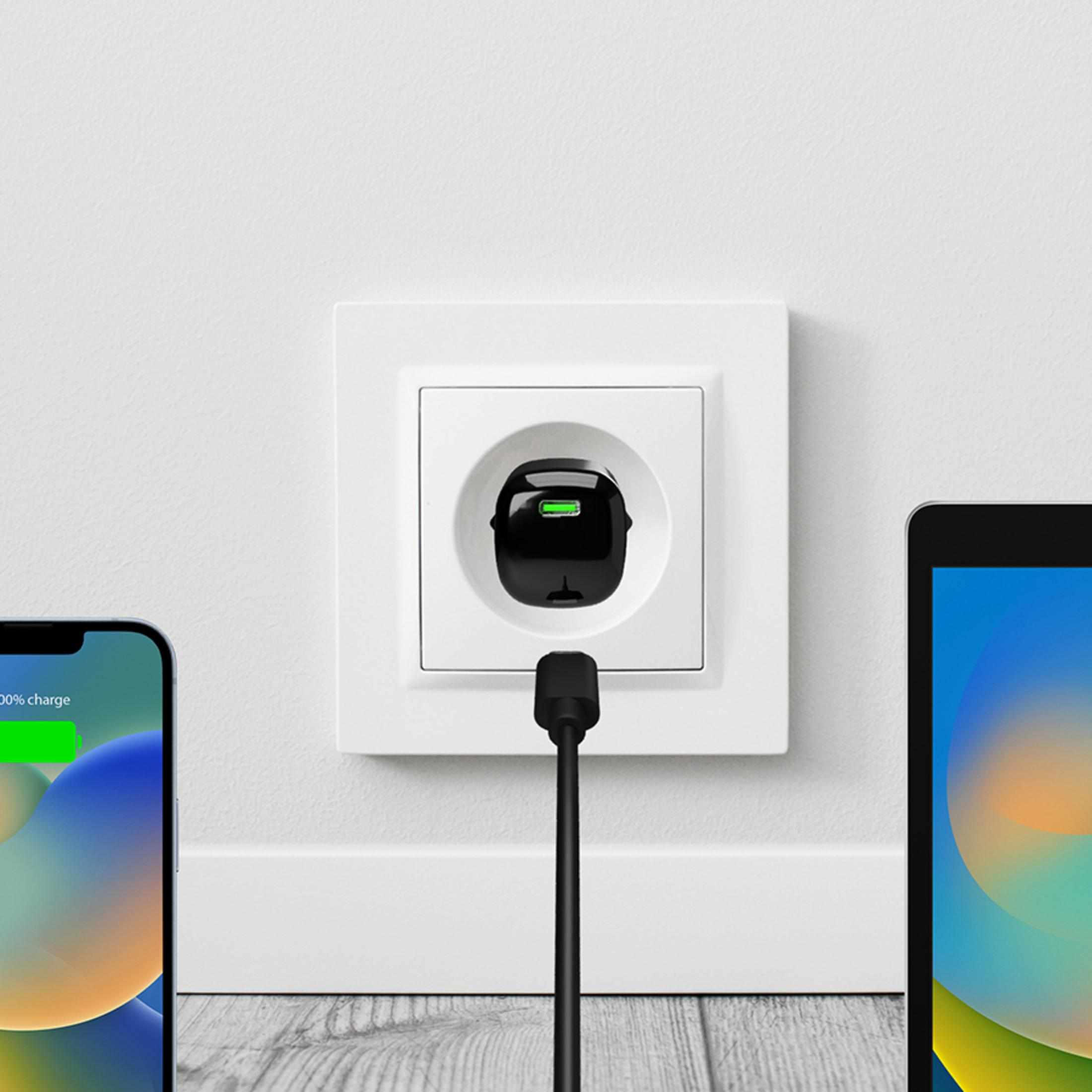 Un telefono e un tablet in carica tramite una presa a muro con adattatore nero.