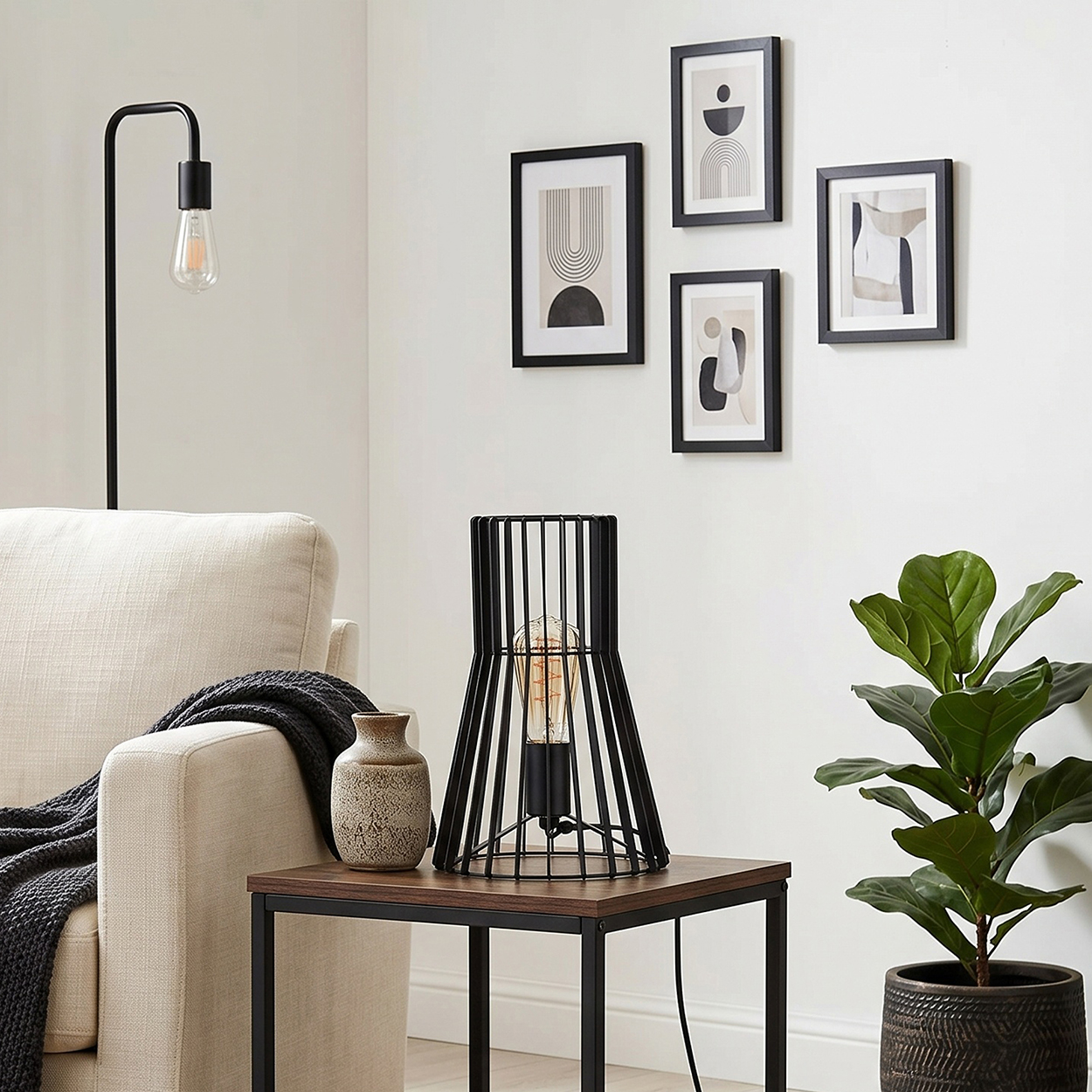 Ein Wohnzimmer mit einem Sessel, einem Beistelltisch mit Lampe und Vase, Bildern an der Wand und einer Pflanze.