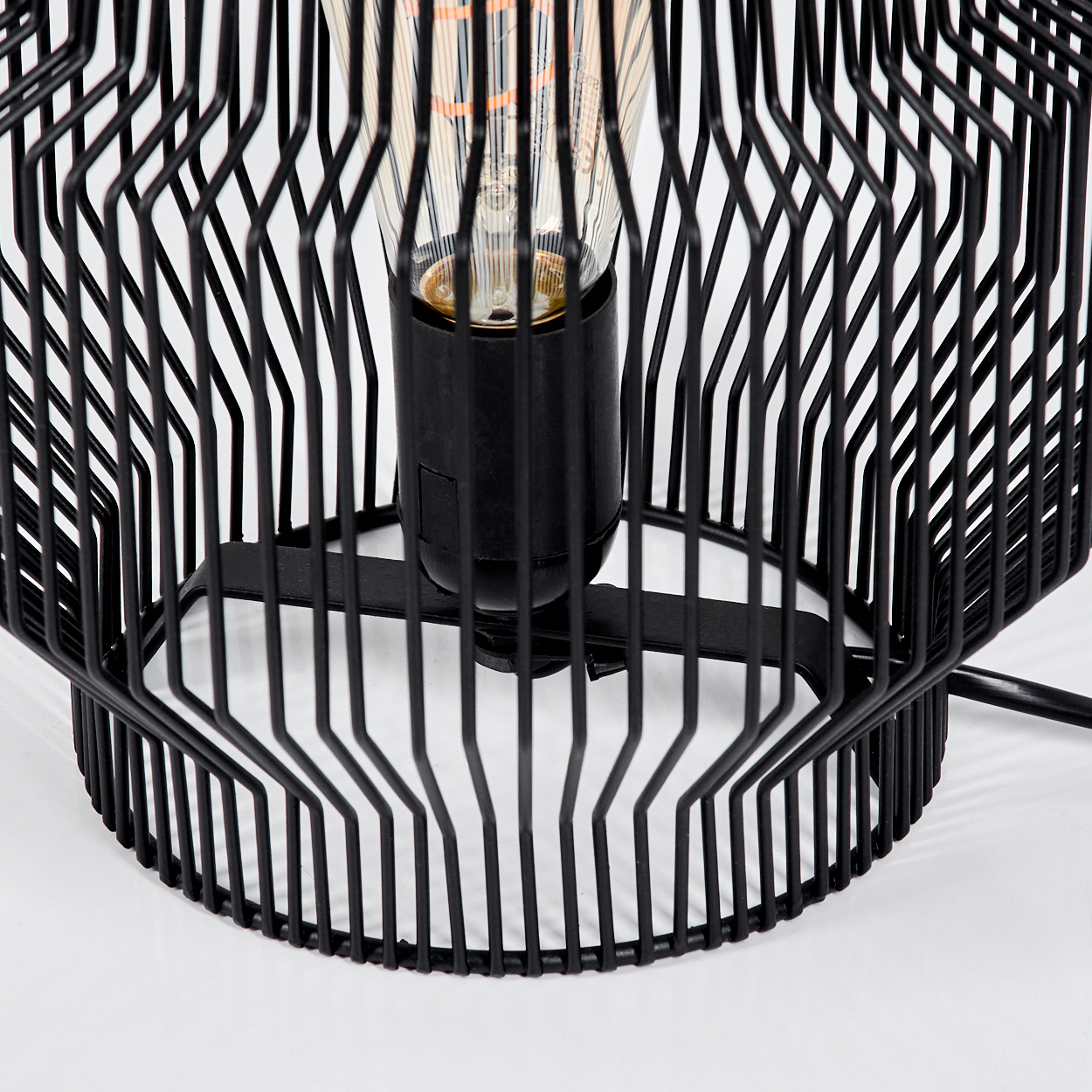 Eine schwarze Metalllampe mit einem sichtbaren Glühfaden-Leuchtmittel.