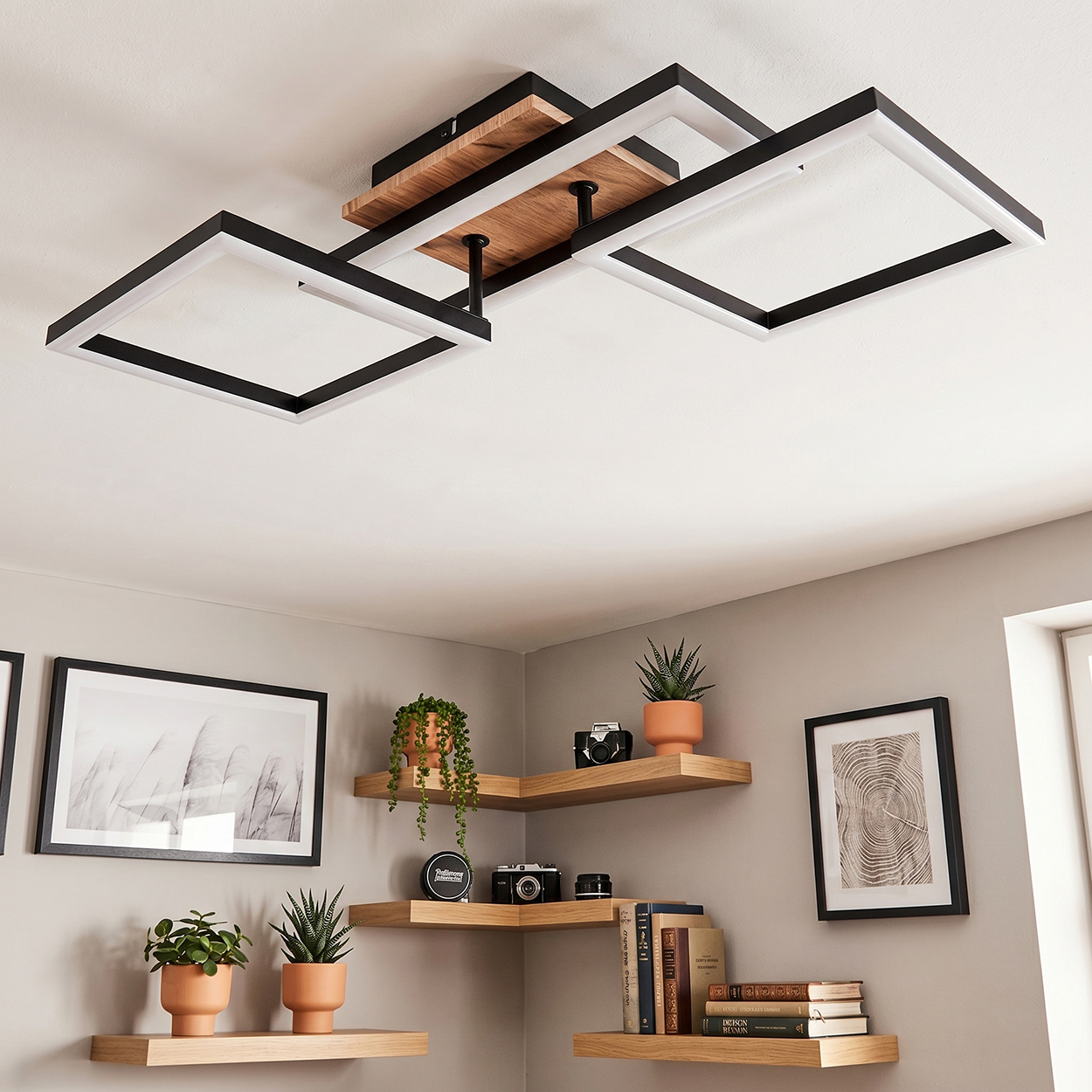 Moderne Deckenleuchte mit Holz und schwarzen Rahmen über Eckregalen mit Dekor.