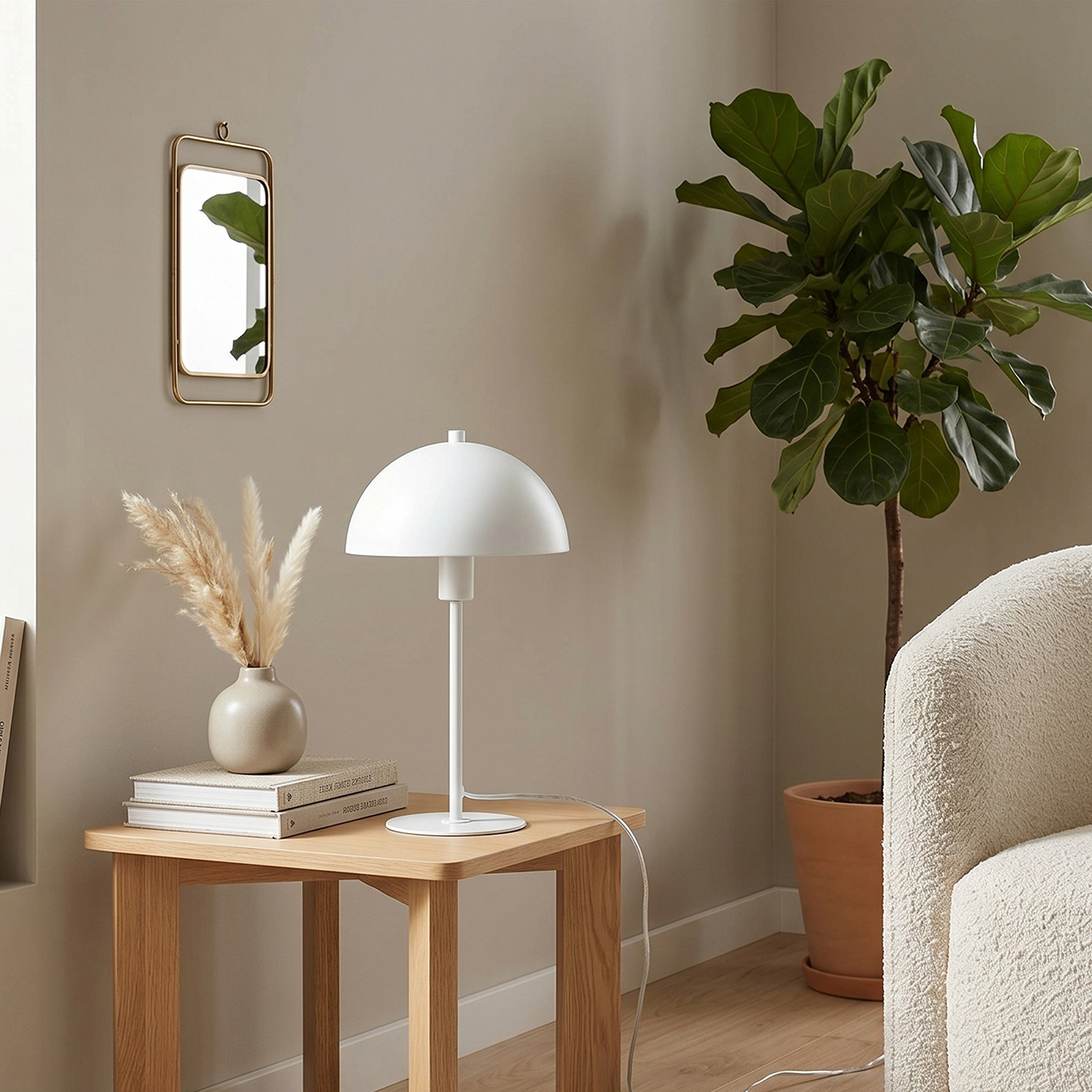 Ein weißer Schreibtischlampe steht auf einem Holztisch neben einem Vasen mit Trockenblumen.