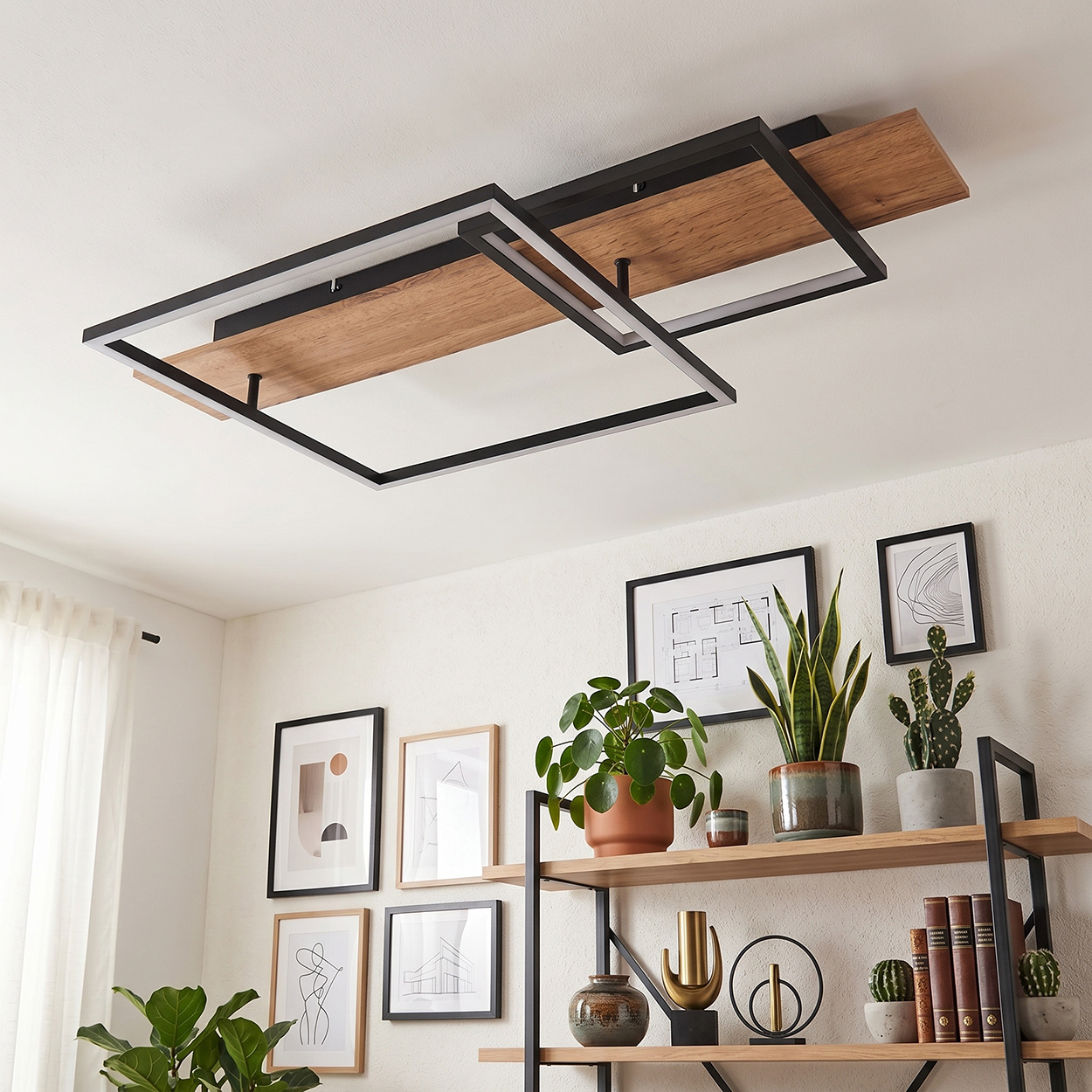 Moderne Deckenleuchte mit Holz und Metallrahmen über einem Regal mit Pflanzen und Bildern.