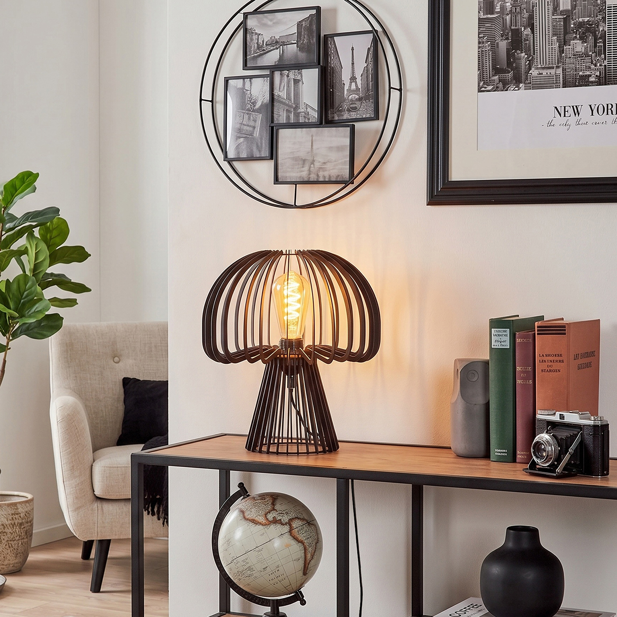 Ein Wohnzimmer mit Lampe, Globus, Büchern und Wanddeko.