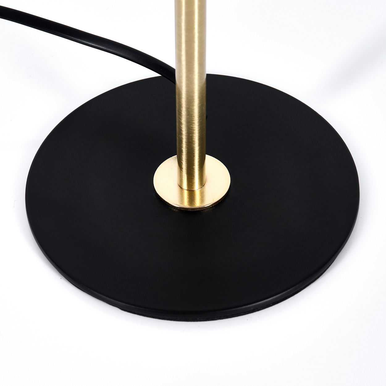 Basis einer Stehlampe mit schwarzem Sockel und Messingstange.