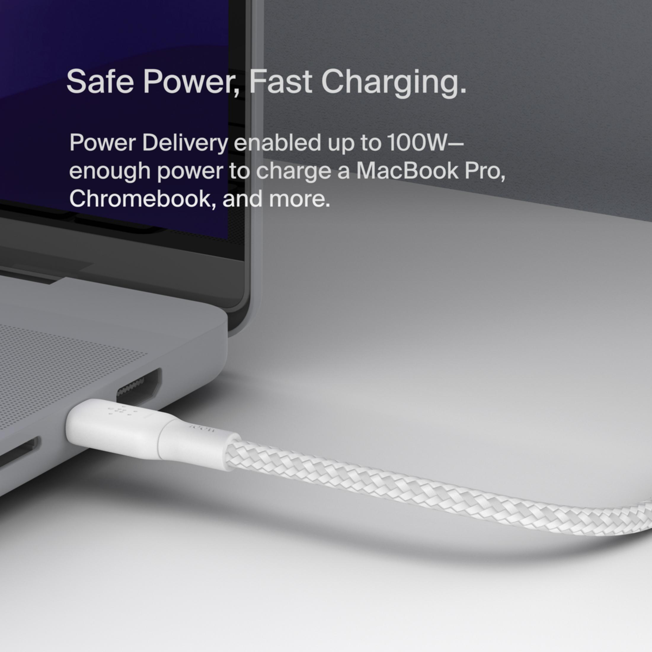 A white charging cable is plugged into a laptop.