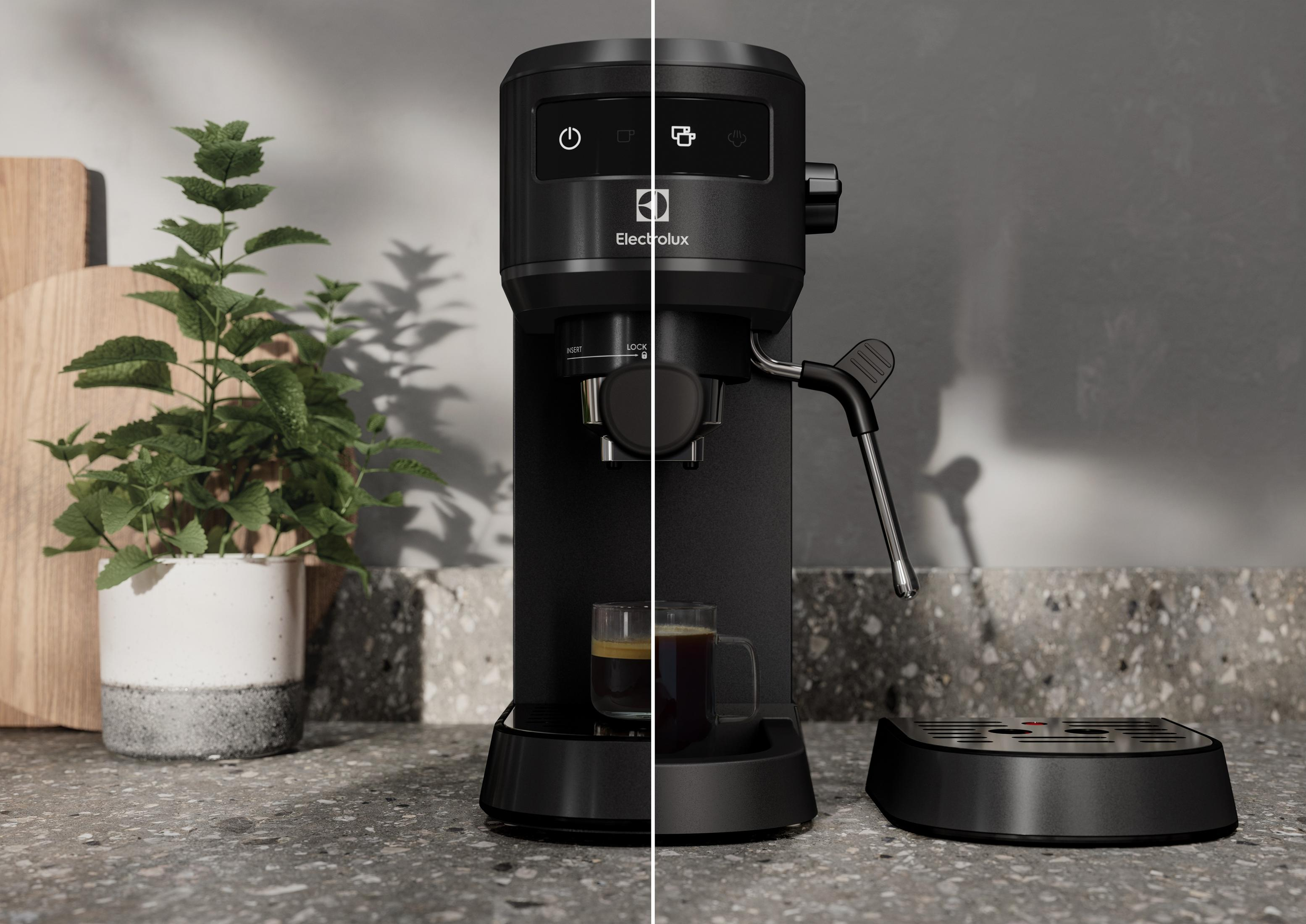 Siyah kahve makinesi yanında bitki bulunan espresso fincanı.