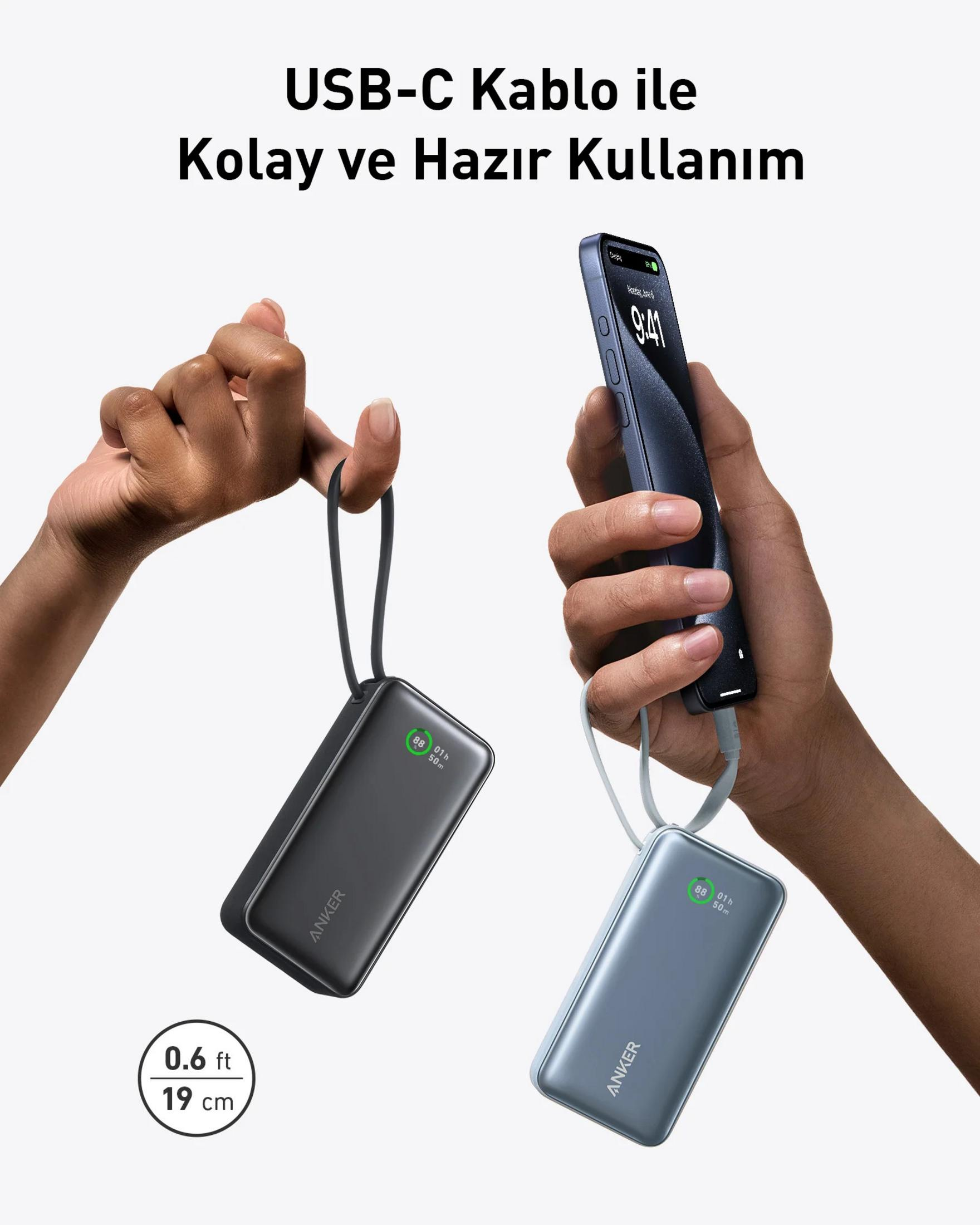 Due power bank Anker, una nera, una blu, tenute da mani. Un telefono in carica.