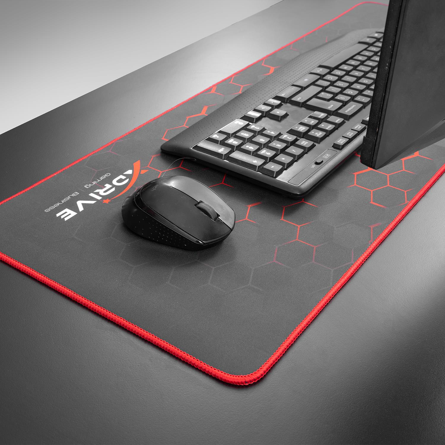 Kırmızı altıgen desenli oyuncu mousepad'i üzerinde siyah klavye ve fare.