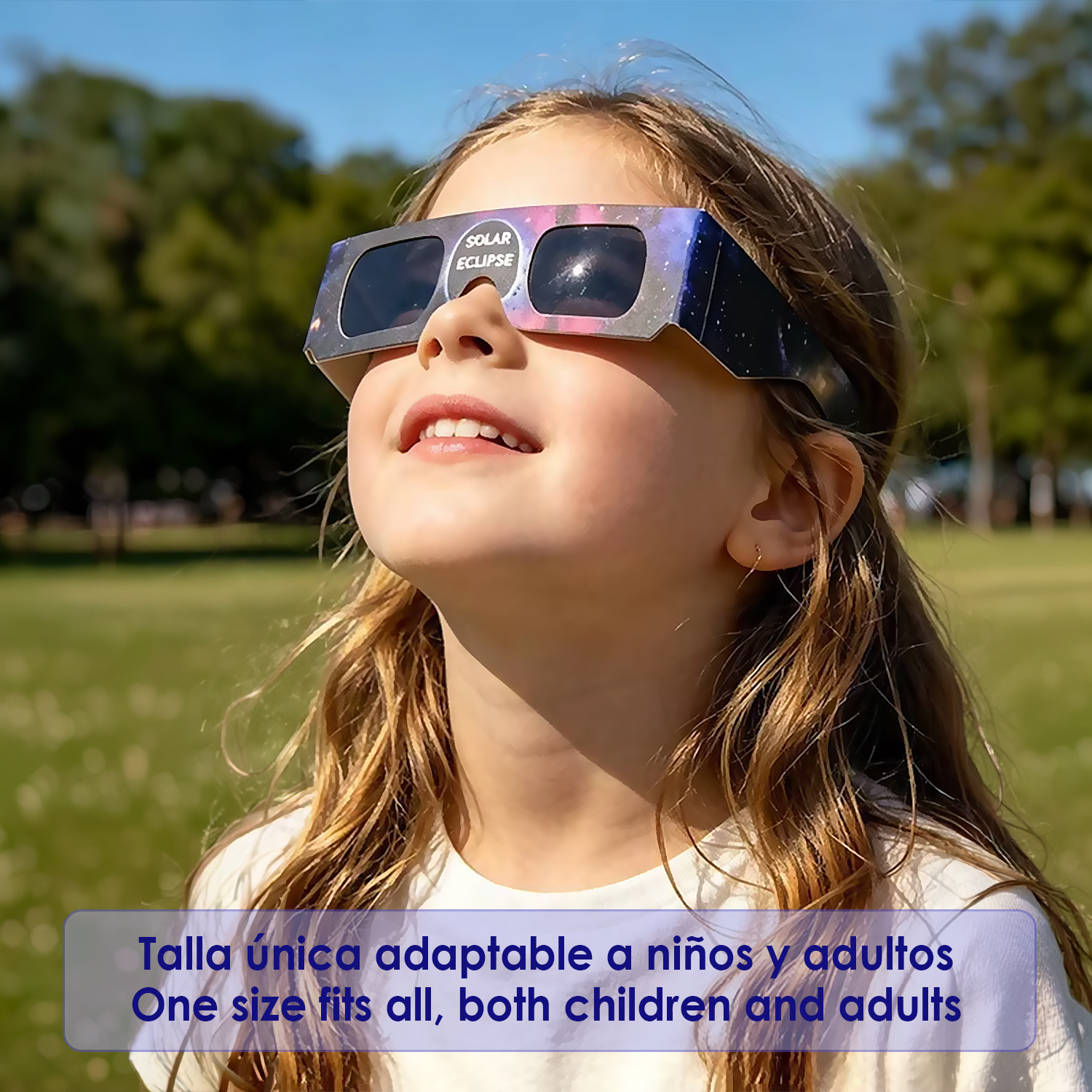 Un niño con gafas de eclipse mira hacia el cielo azul.