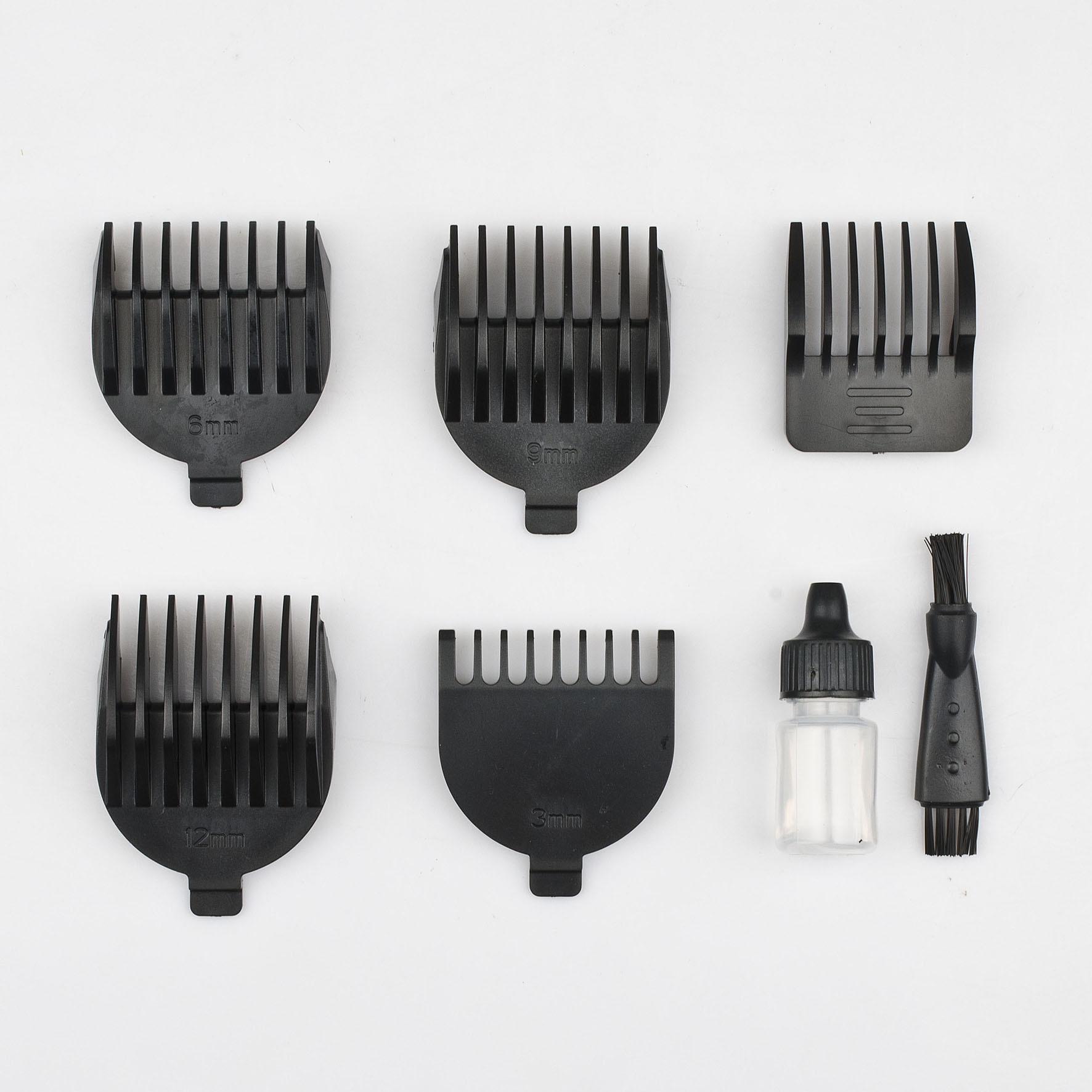 Beş adet siyah saç kesme makinesi tarağı (3mm, 6mm, 9mm, 12mm), küçük bir yağ şişesi ve fırça.