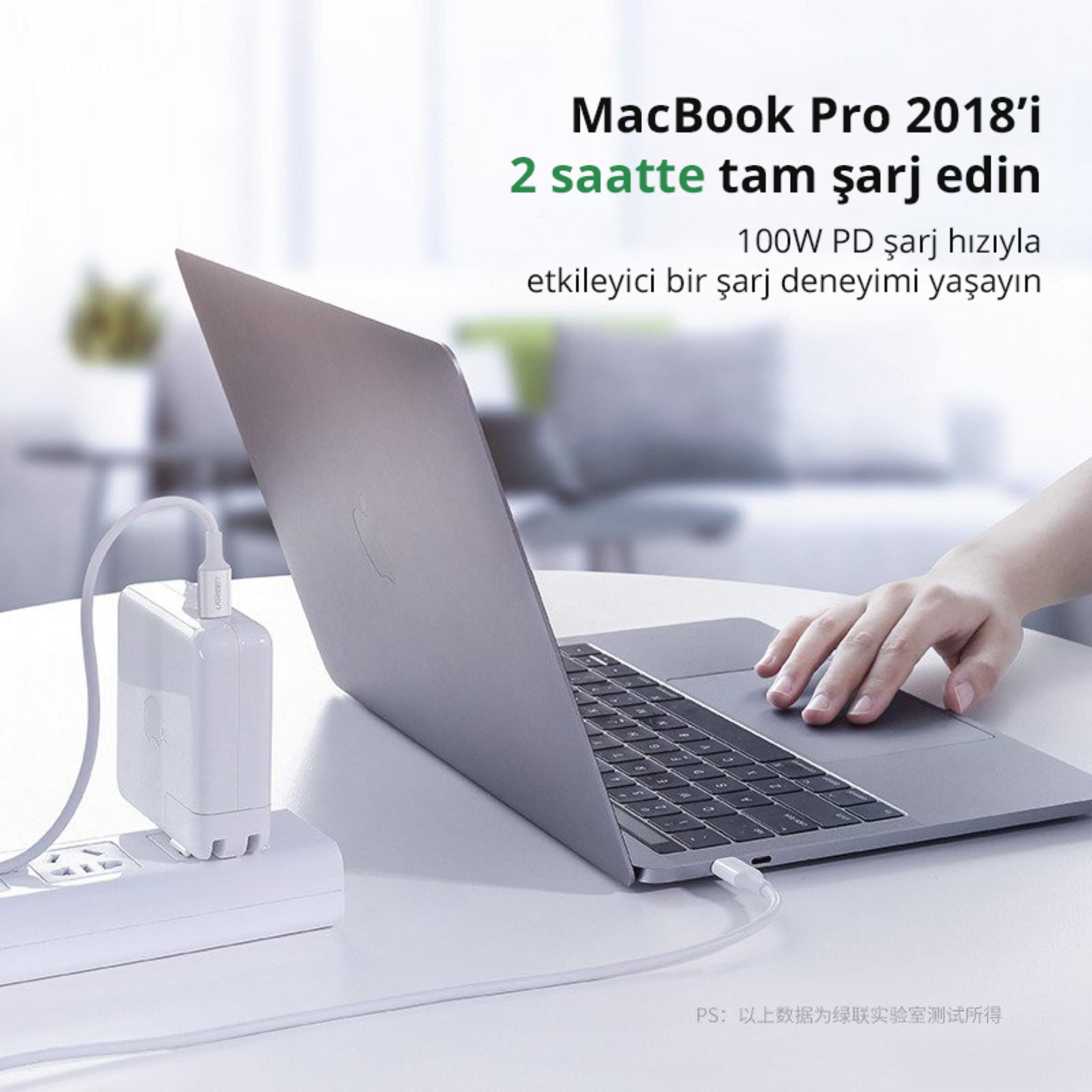 Un MacBook Pro si carica con un adattatore bianco tramite cavo USB-C.
