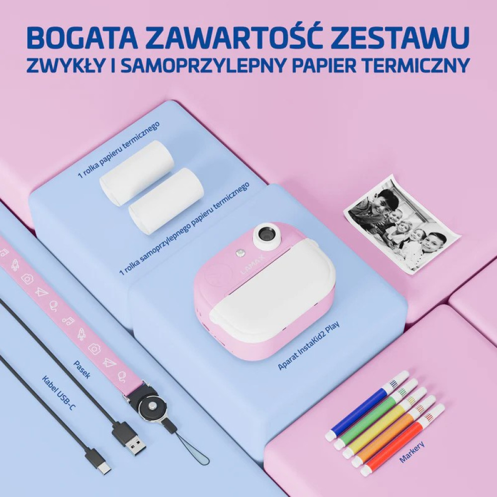 Różowy aparat natychmiastowy z akcesoriami: rolki papieru, kabel USB-C, smycz, zdjęcia i markery.