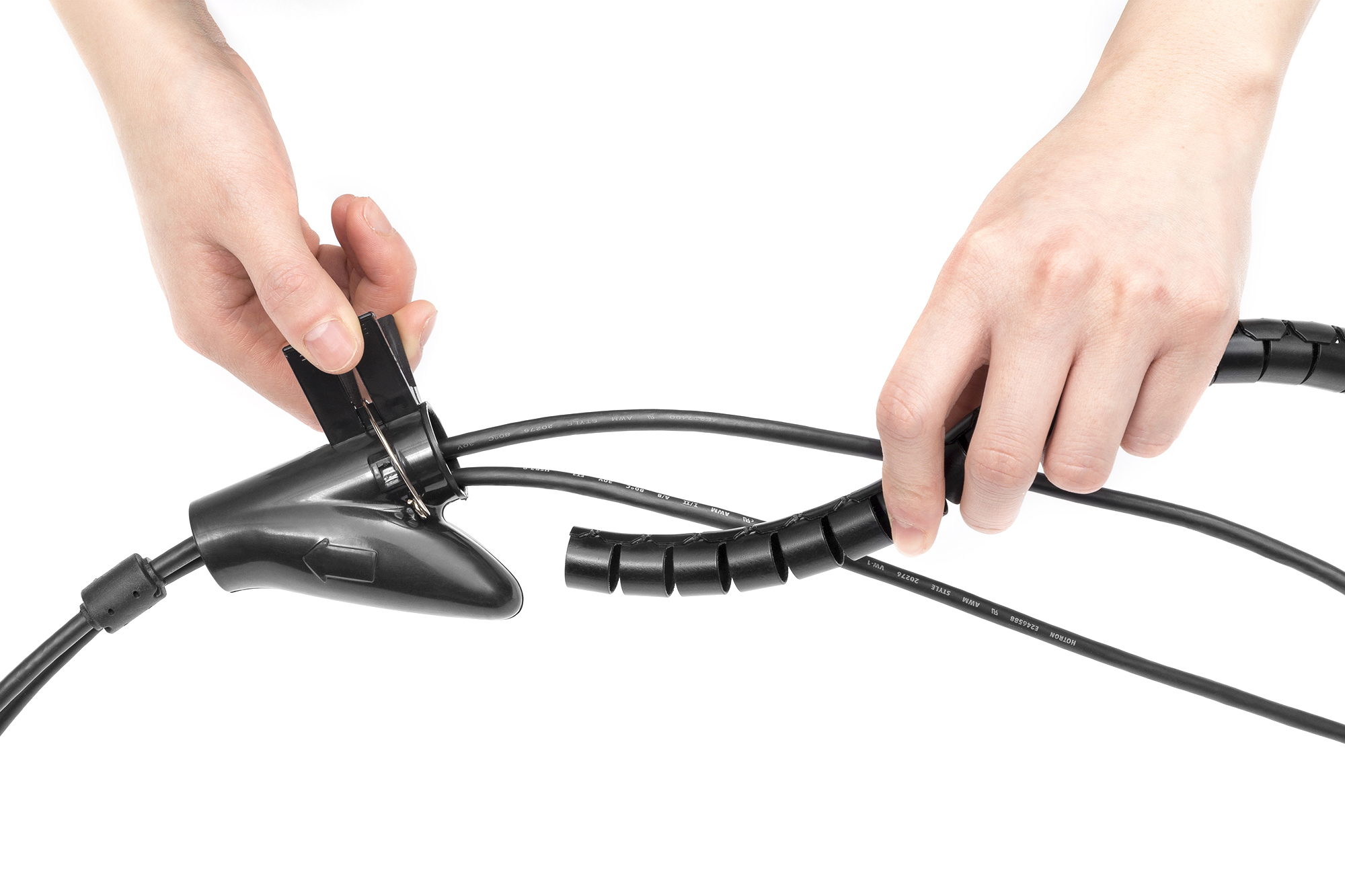 Hände ordnen schwarze Kabel mit Spiralmanschette und schwarzem Stecker.