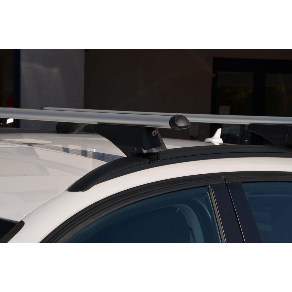 Silberne Dachgepäckträger mit schwarzen Halterungen auf einem weißen Auto.