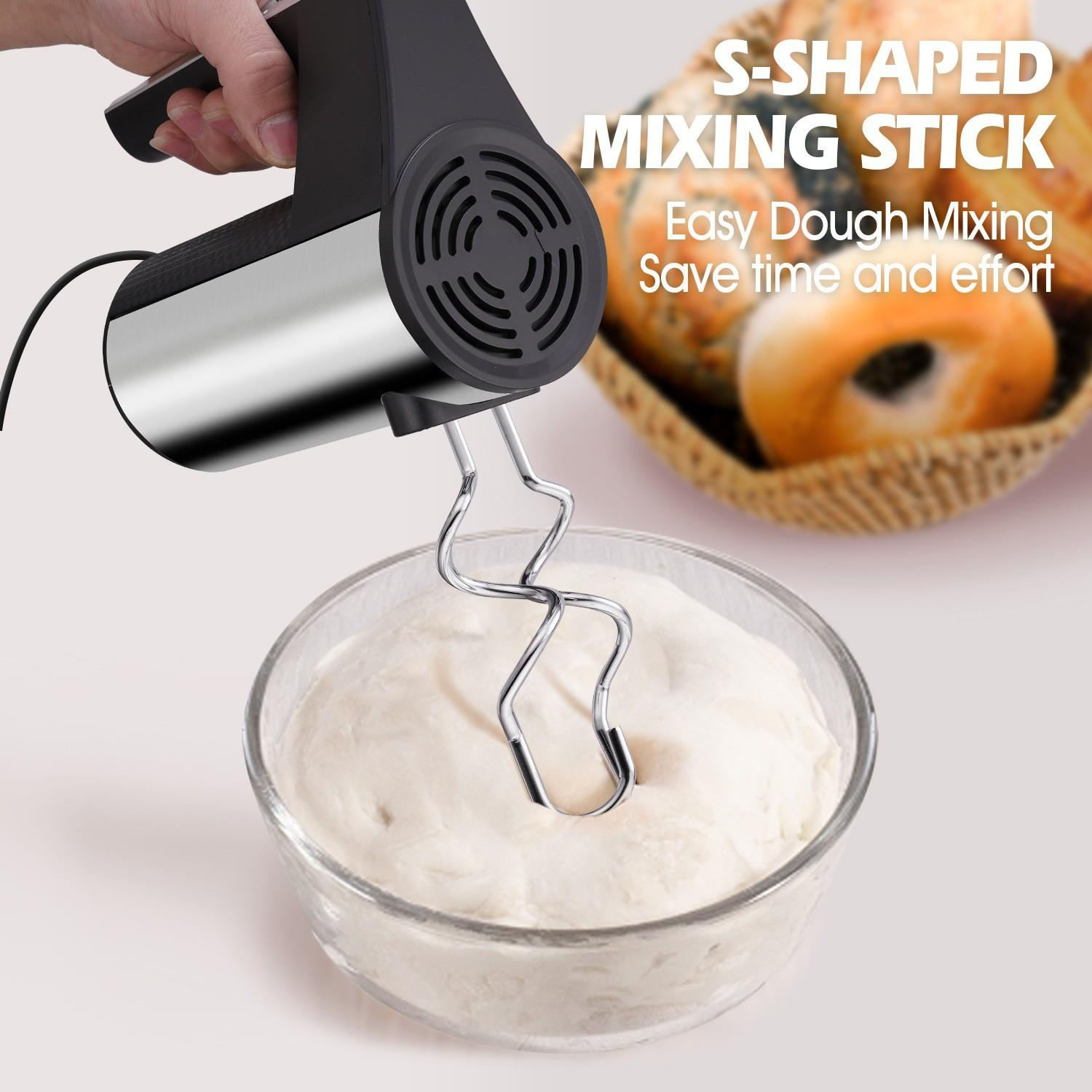 Ein Handmixer mit S-förmigem Stab rührt Teig in einer Glasschüssel. Daneben ein Korb mit Brot.