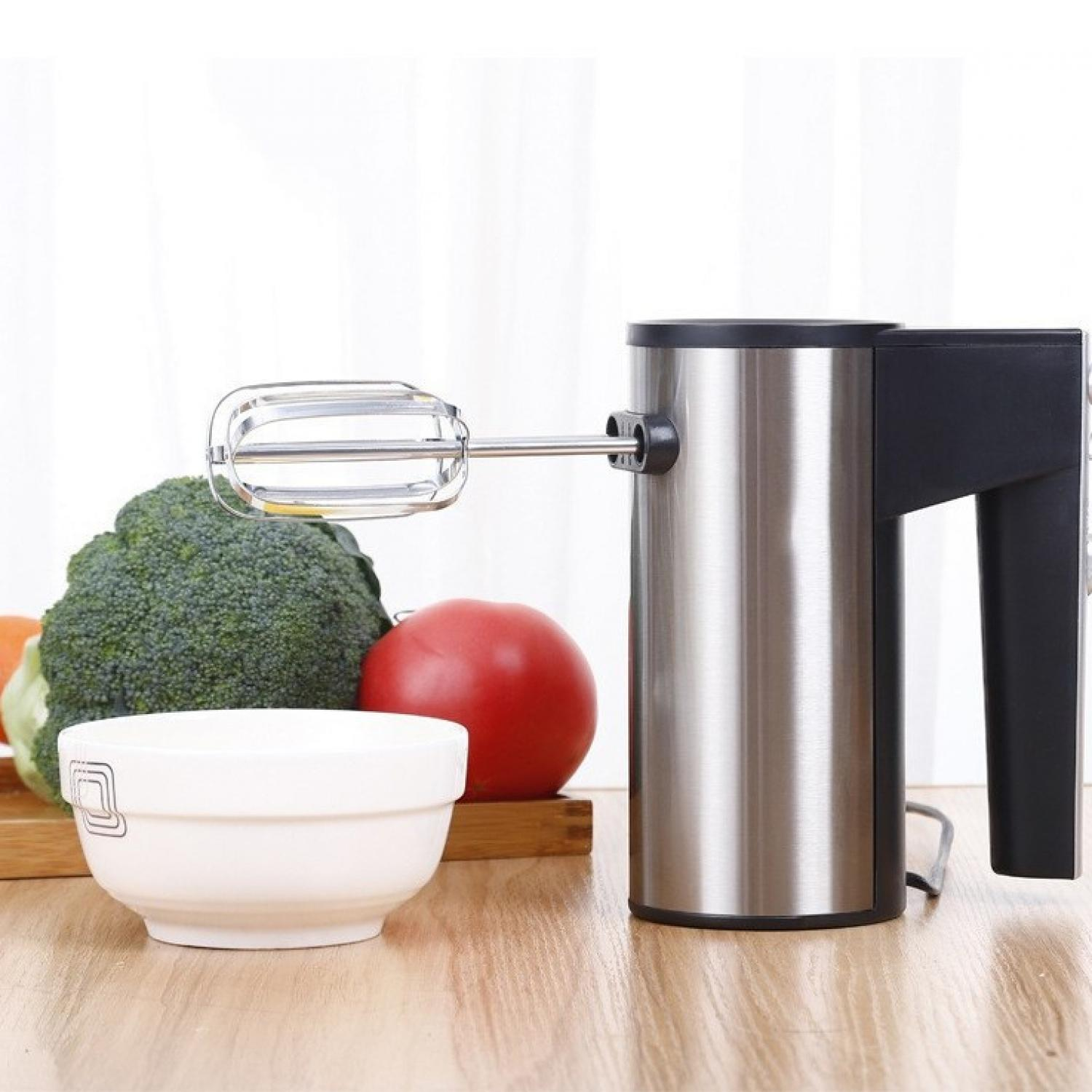 Edelstahl-Handmixer mit Aufsätzen, daneben Brokkoli, Tomate, Schüssel und Holzbrett.