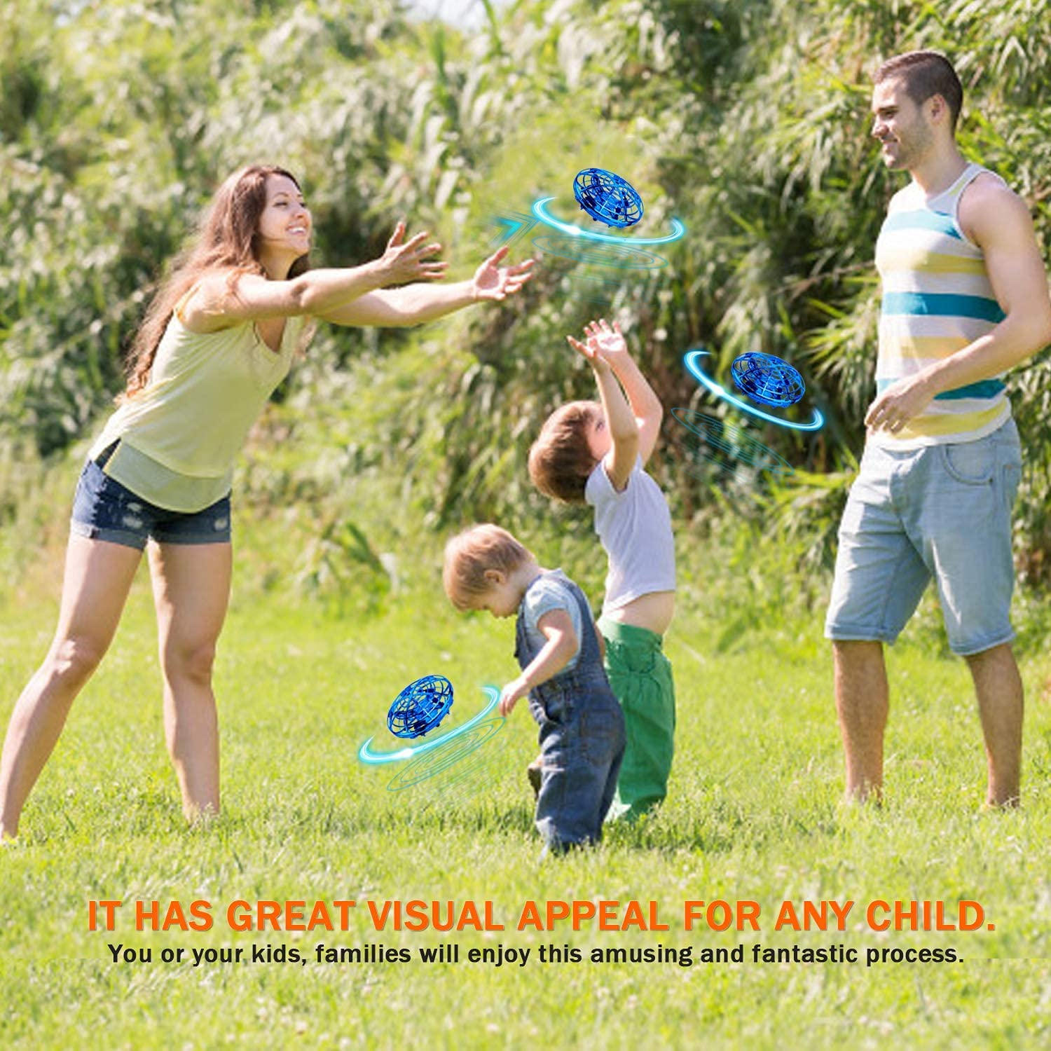 Familie spielt mit Drohnen im Gras. Mann, Frau und Kinder lachen.