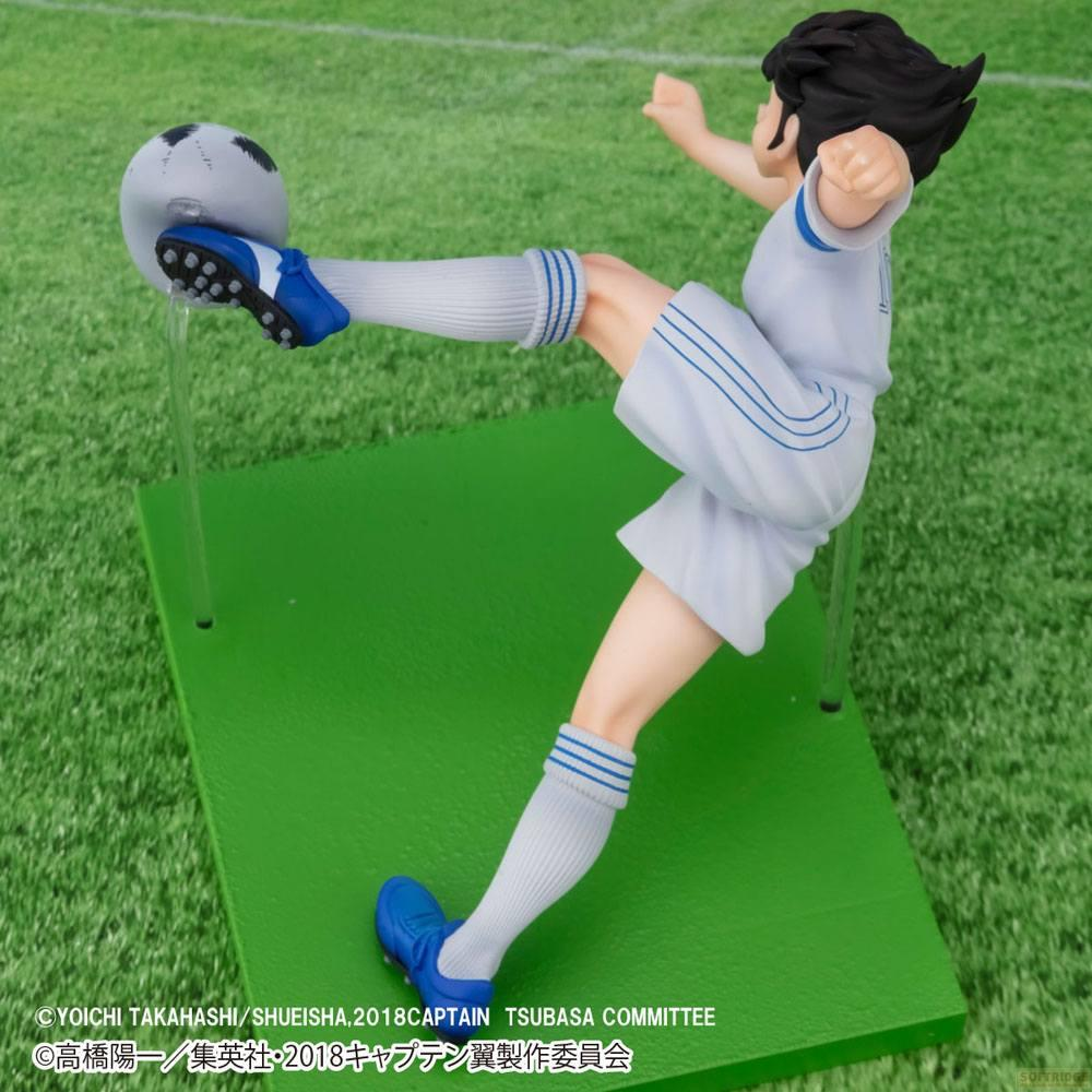 Eine Fußballfigur tritt gegen einen Ball auf einem grünen Feld.