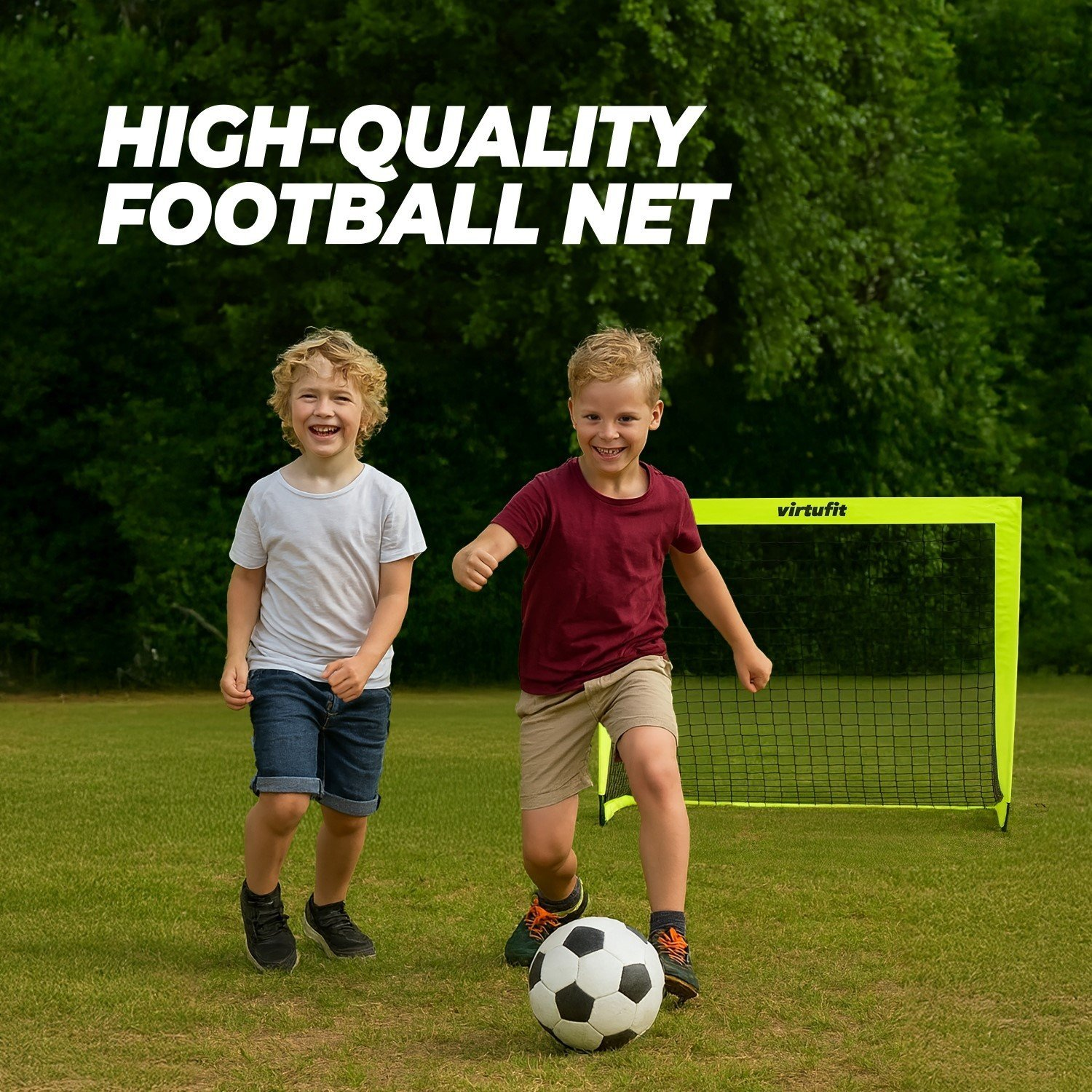 Zwei Jungen spielen Fußball auf einem Rasenfeld mit einem leuchtend gelben Netz im Hintergrund.