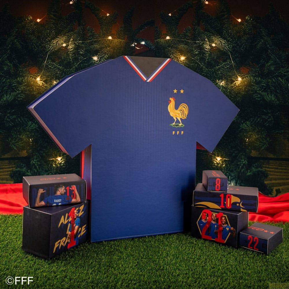 Großes blaues Trikot mit Hahn-Logo, umgeben von Geschenkschachteln auf Kunstrasen.