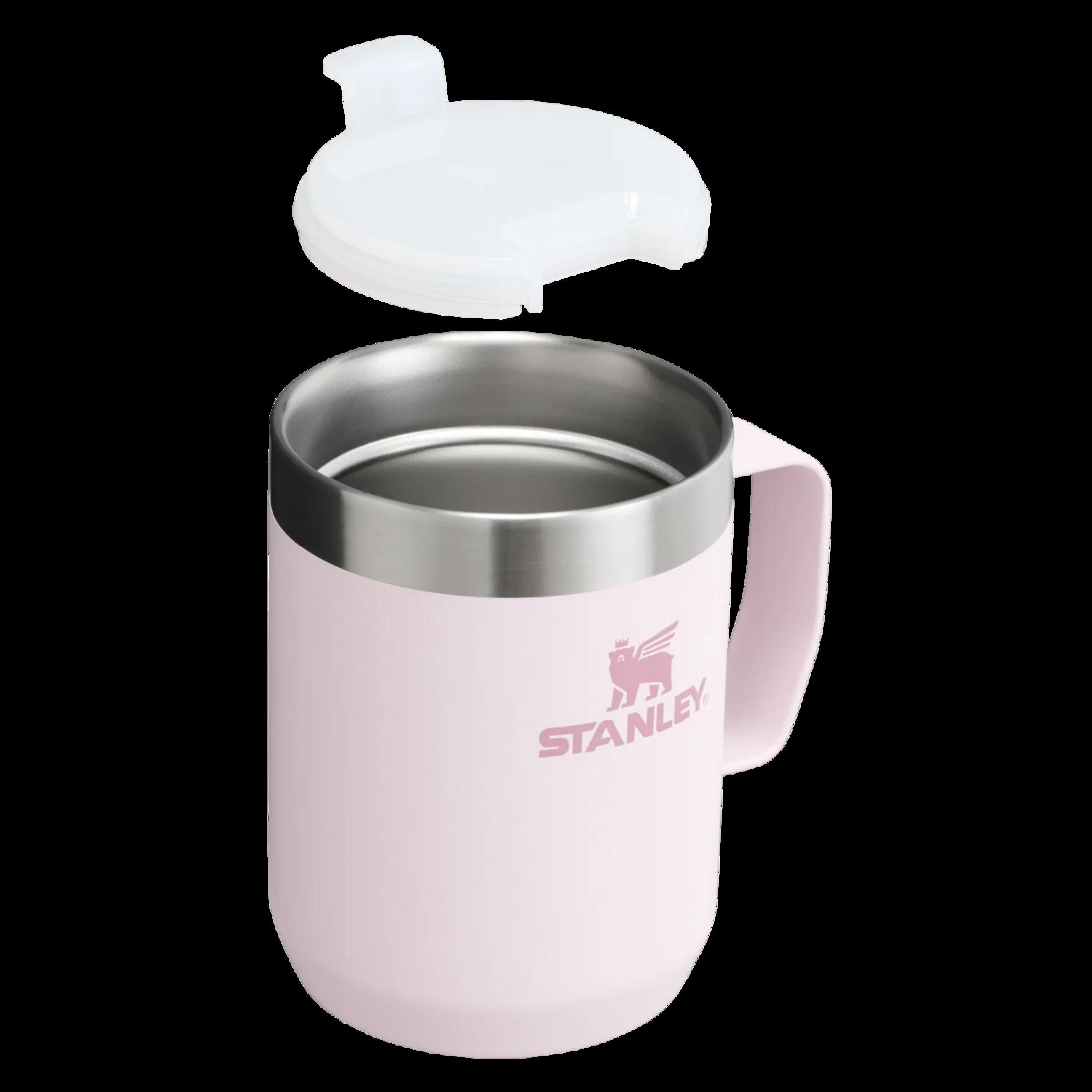 Eine rosafarbene Stanley-Tasse mit Griff und einem weißen Deckel.