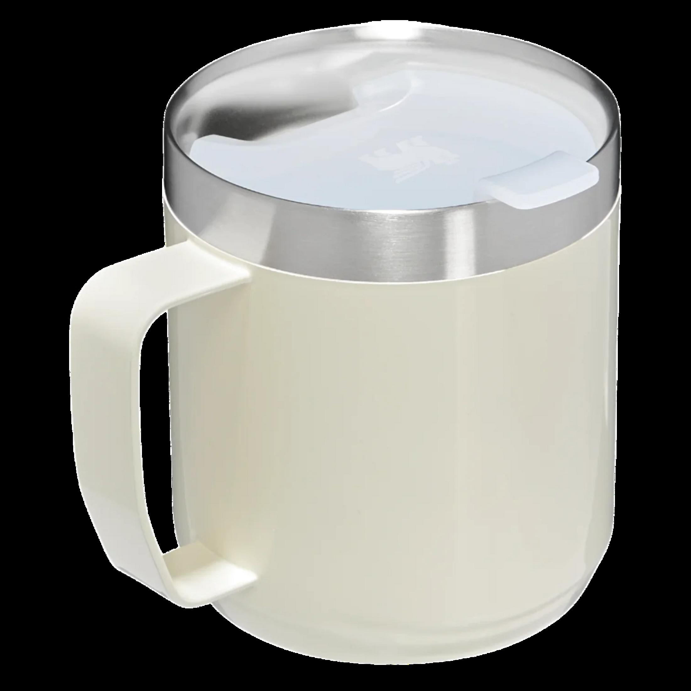Une tasse couleur crème avec un bord argenté et un couvercle blanc.