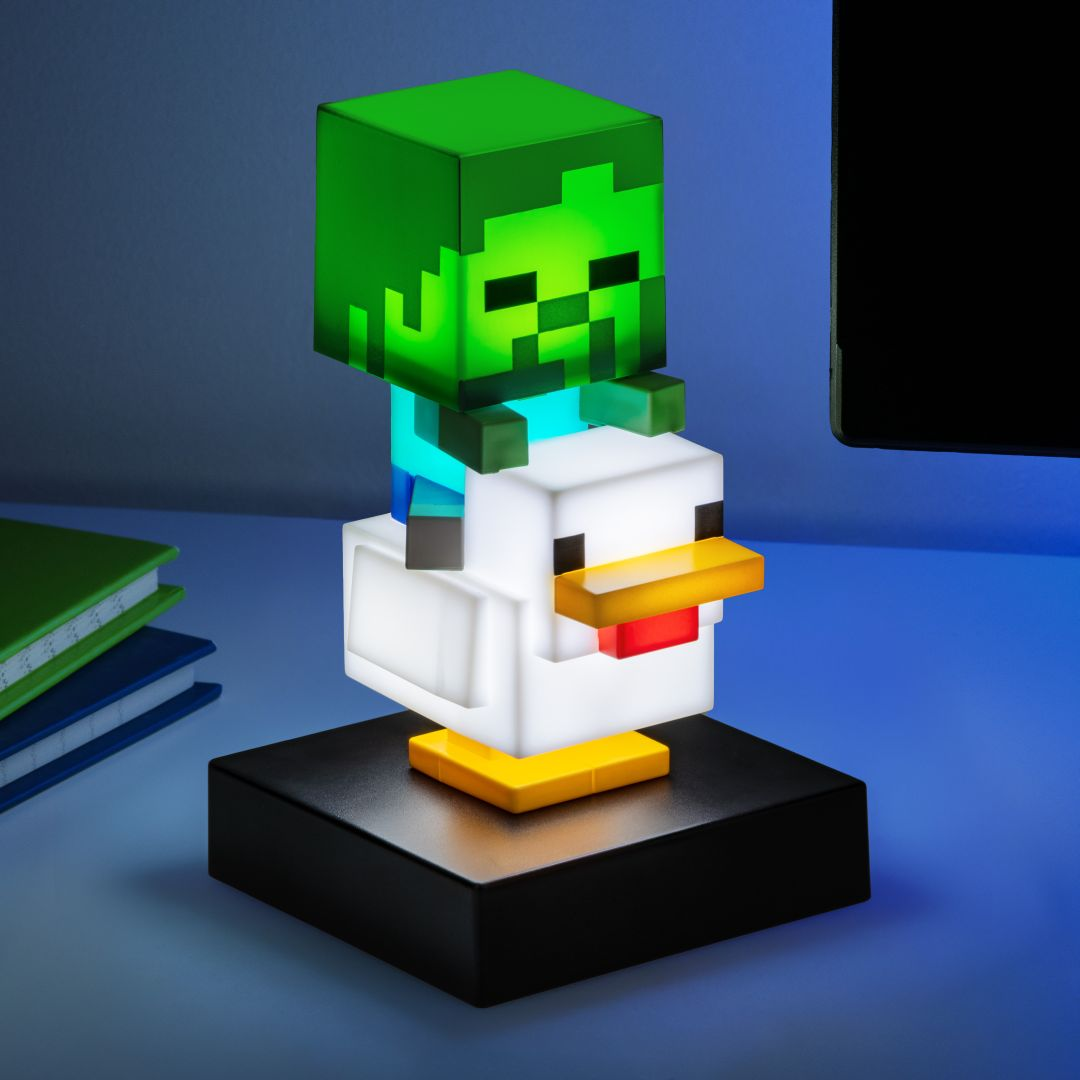 Zombie z Minecraft siedzi na podświetlanej białej figurce kurczaka na czarnej podstawie.