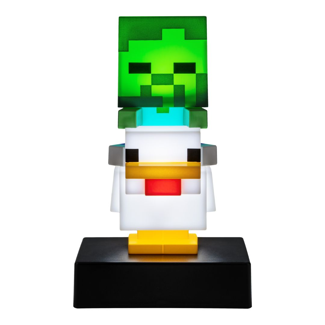 Figurka Minecraft z zieloną głową zombie i białym korpusem kurczaka na czarnej podstawie.