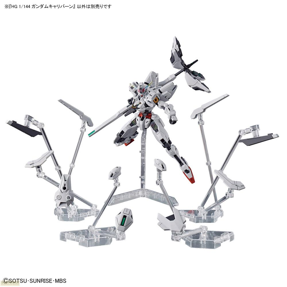 Ein weißer und grauer Gundam-Modellbausatz mit Zubehör auf durchsichtigen Ständern.