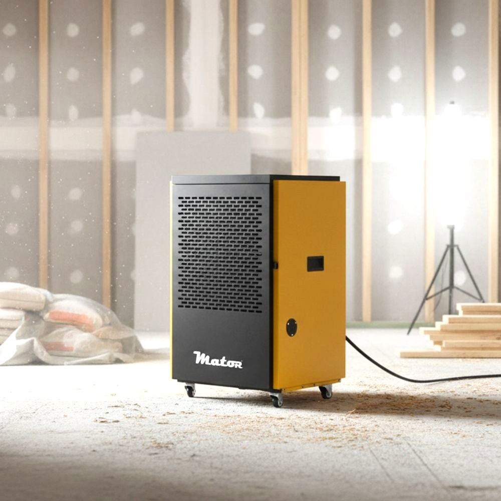 Un deshumidificador amarillo y negro con ruedas en una sala de construcción.