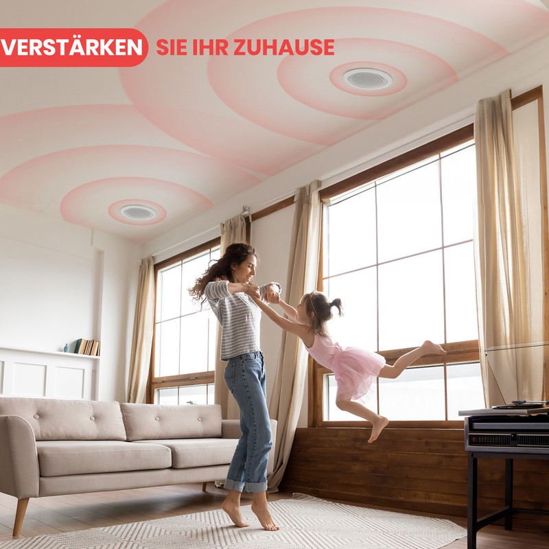 Mutter und Kind tanzen im Wohnzimmer, Deckenlautsprecher sind sichtbar.
