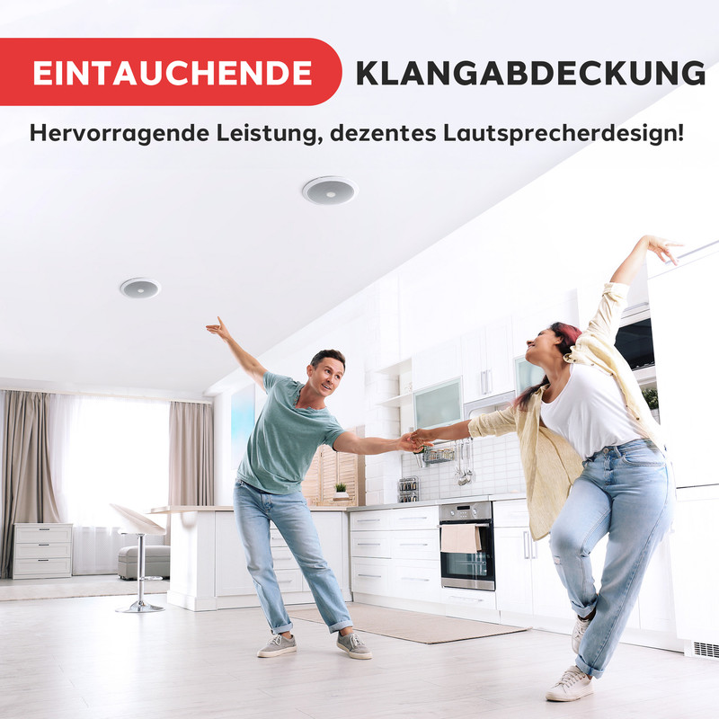 Ein Paar tanzt in einer modernen Küche mit Einbaulautsprechern an der Decke.