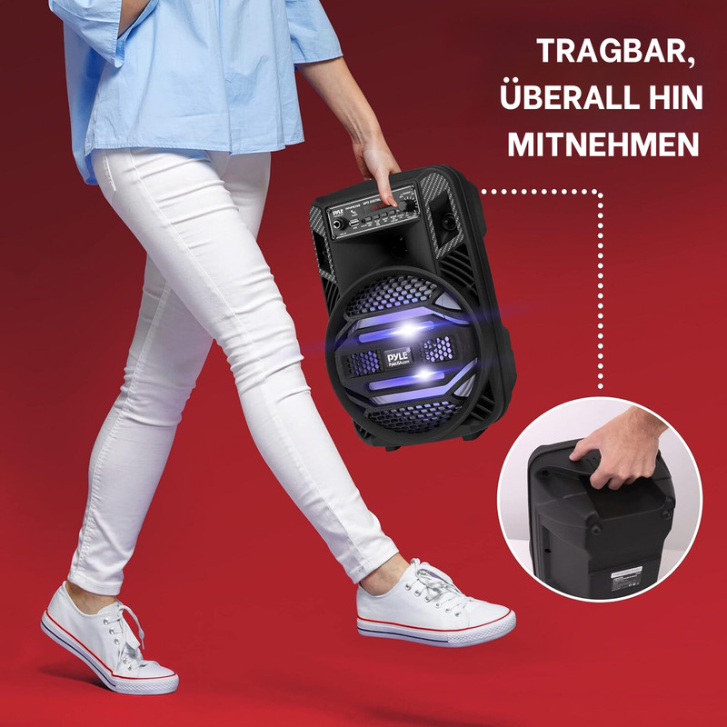 Eine Person in weißen Jeans trägt eine schwarze Lautsprecherbox.