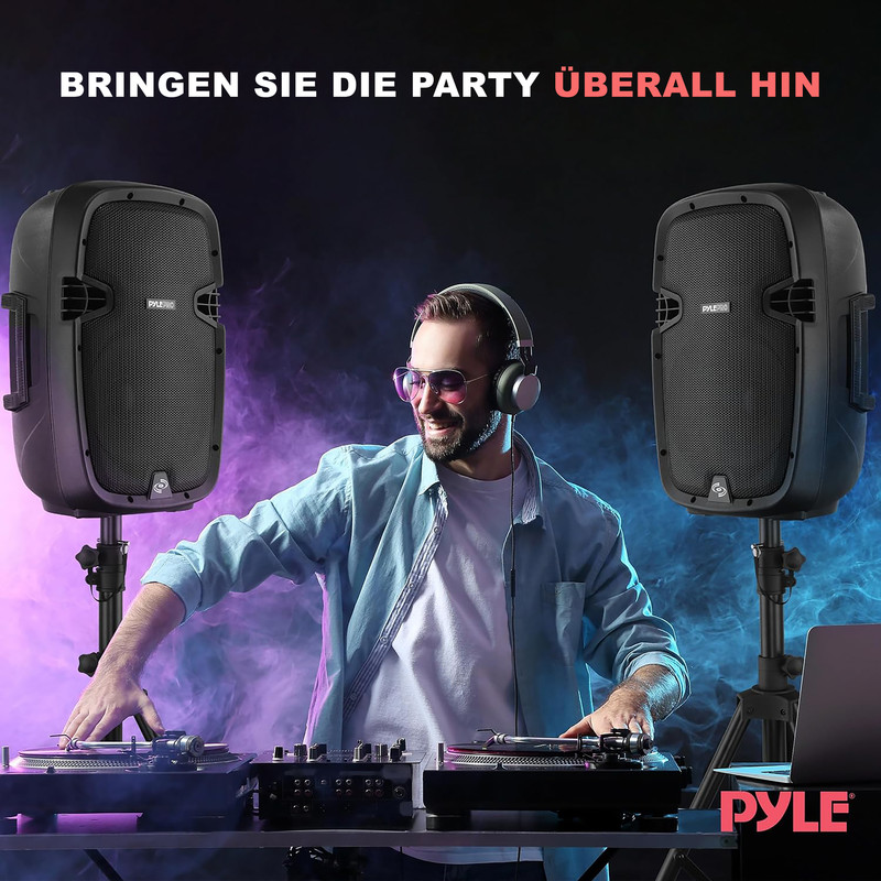 DJ mit Kopfhörern legt Musik auf, zwei Lautsprecher und Nebel im Hintergrund.