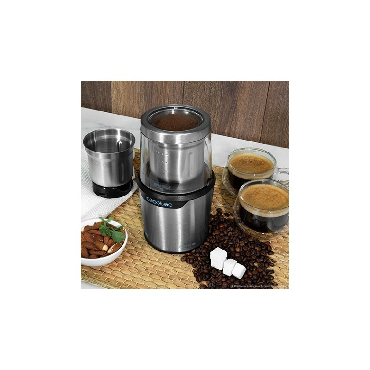 Coffee grinder with two espresso cups, almonds, and coffee beans.