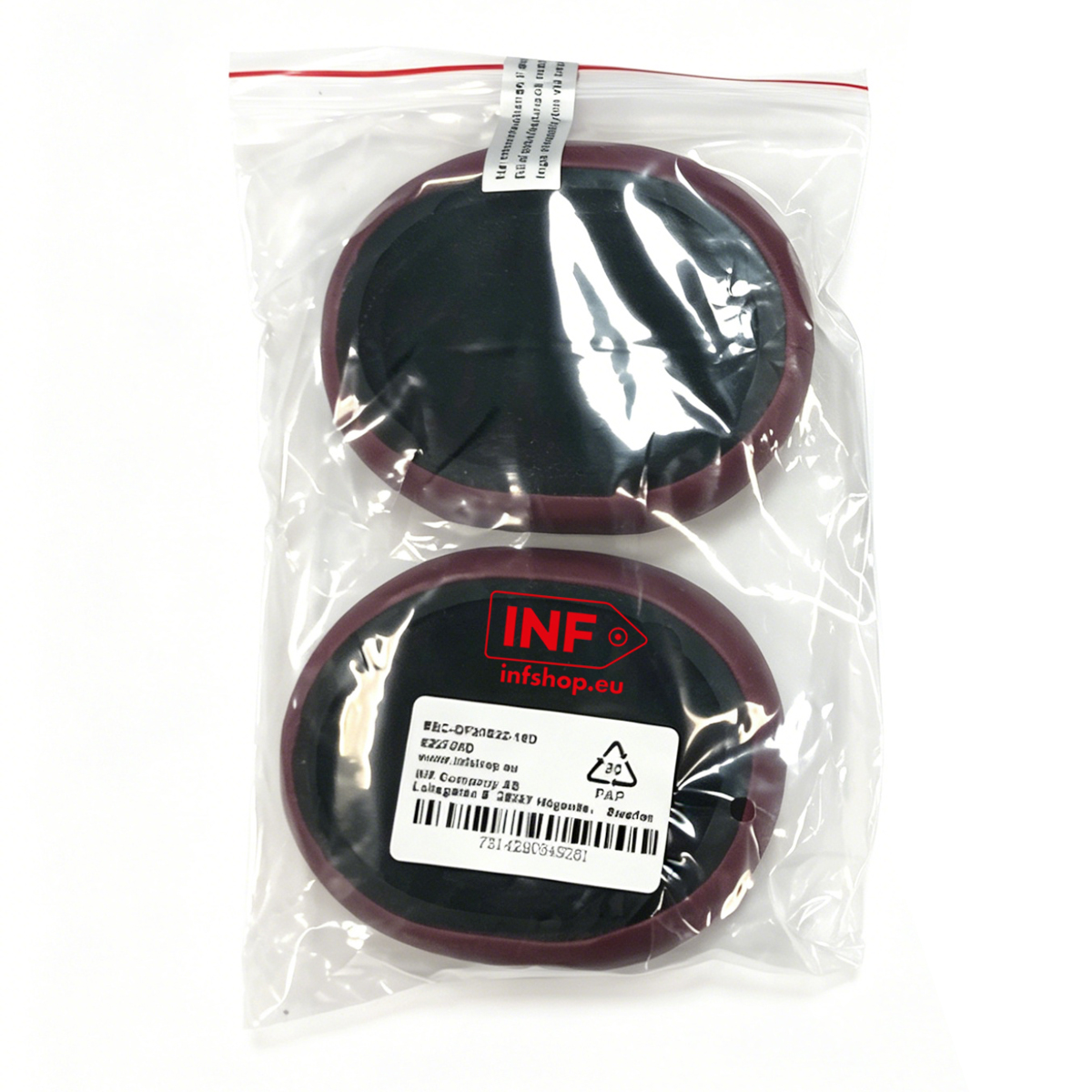 Due toppe rotonde nere con bordo rosso scuro in un sacchetto di plastica.