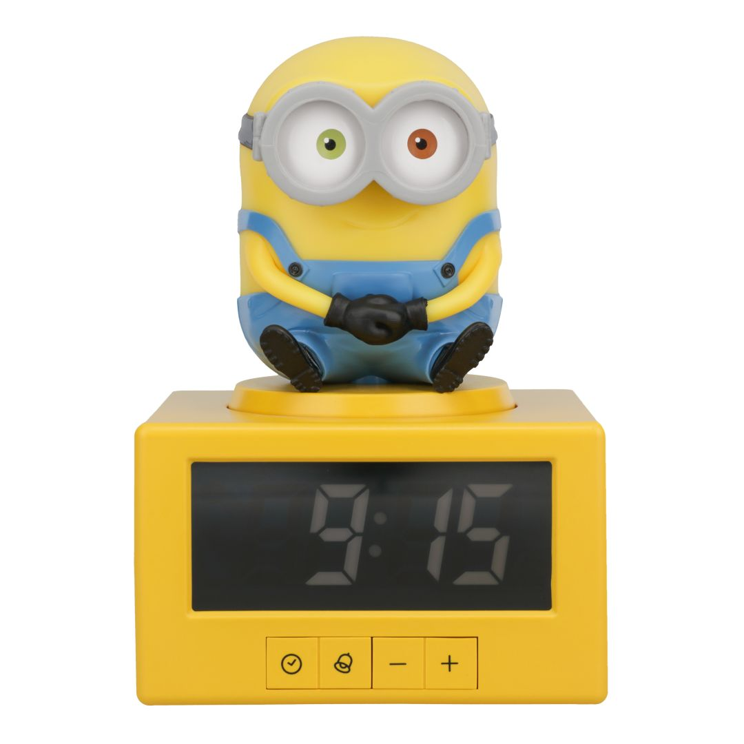 Żółty budzik Minion pokazujący 9:15, z przyciskami poniżej.