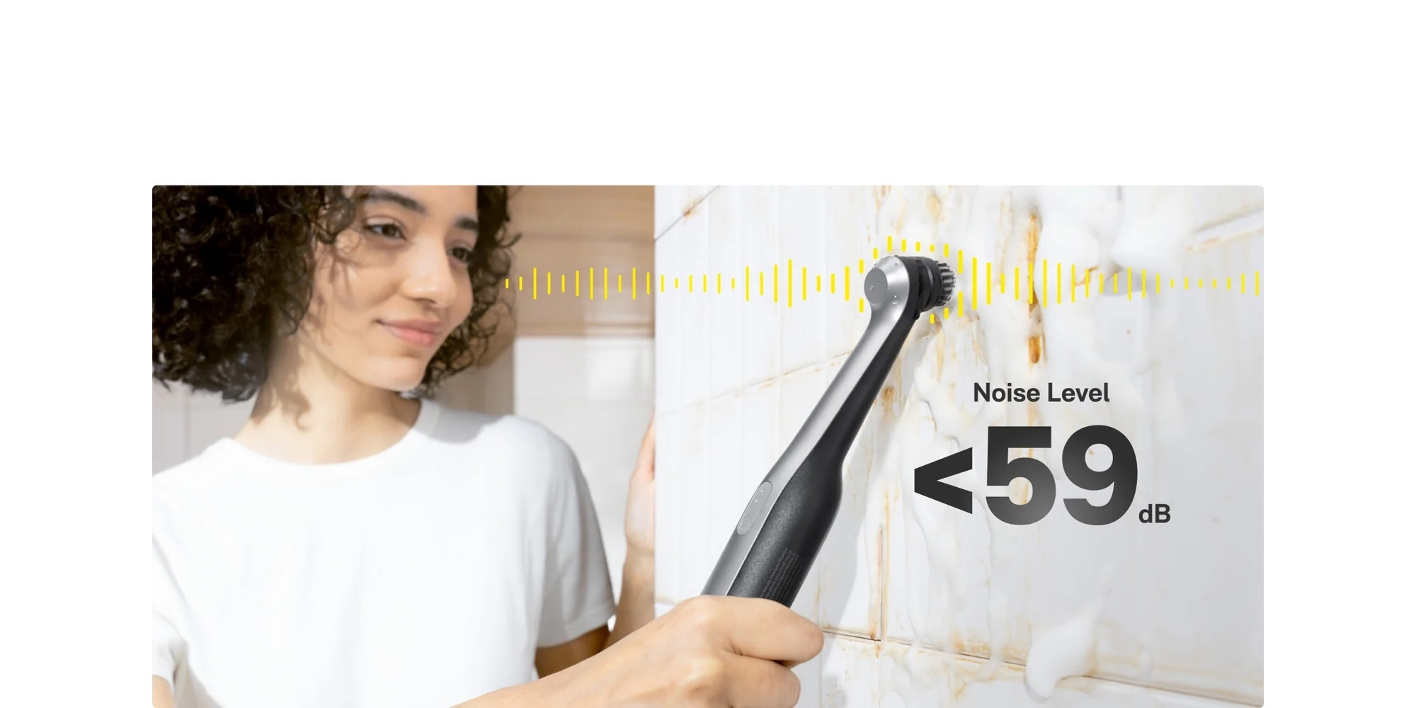 Kobieta czyści płytki szczotką. Poziom hałasu poniżej 59 dB.