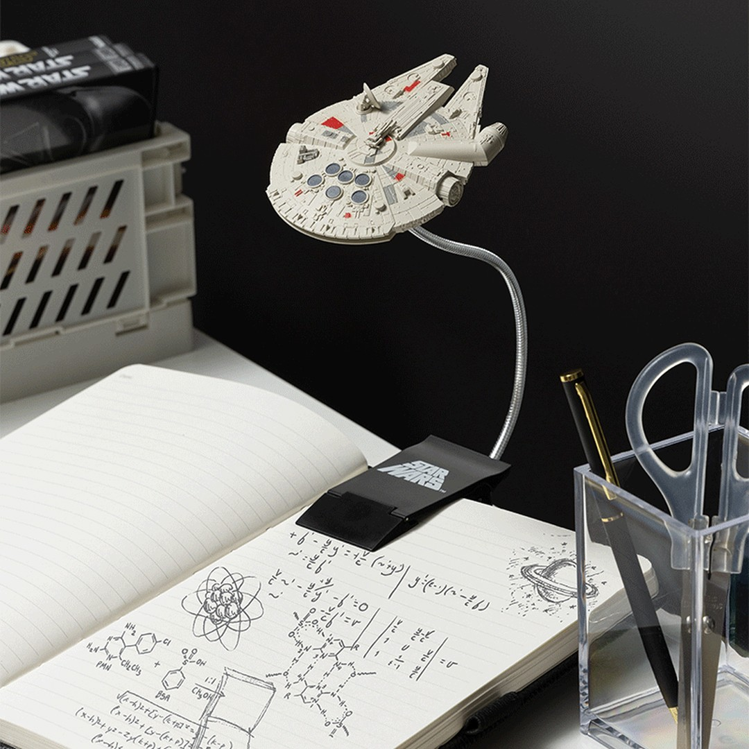 Lampa Millennium Falcon nad notatnikiem z formułami. Obok długopisy i nożyczki.