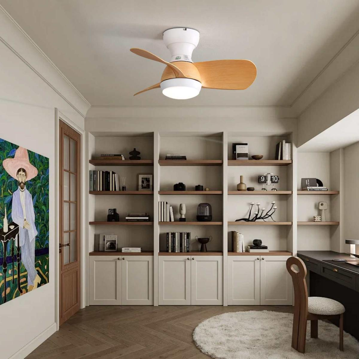 Ein Raum mit Deckenventilator, Bücherregalen, einem Gemälde und einem Schreibtisch.