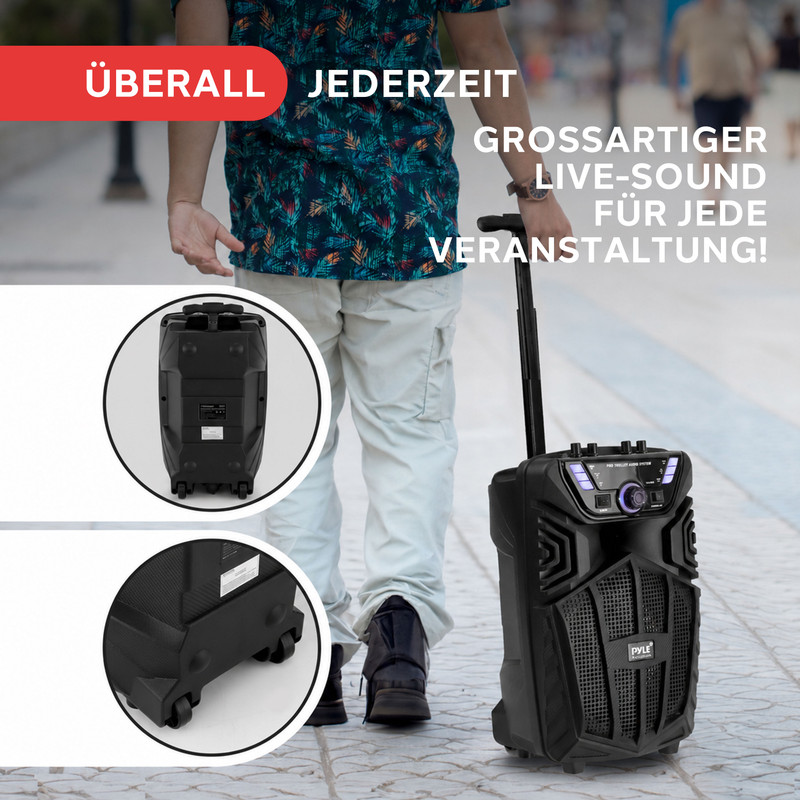 Person zieht einen schwarzen Lautsprecher auf Rädern, mit Detailaufnahmen.