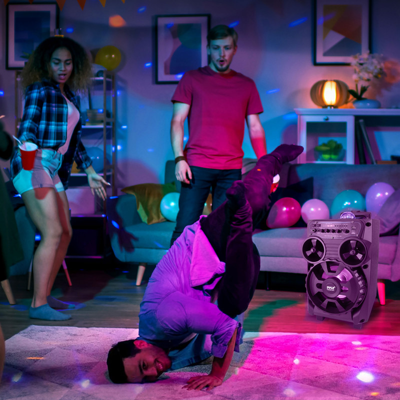 Gruppe tanzt auf Party mit Lichteffekten. Ein Mann macht einen Handstand.
