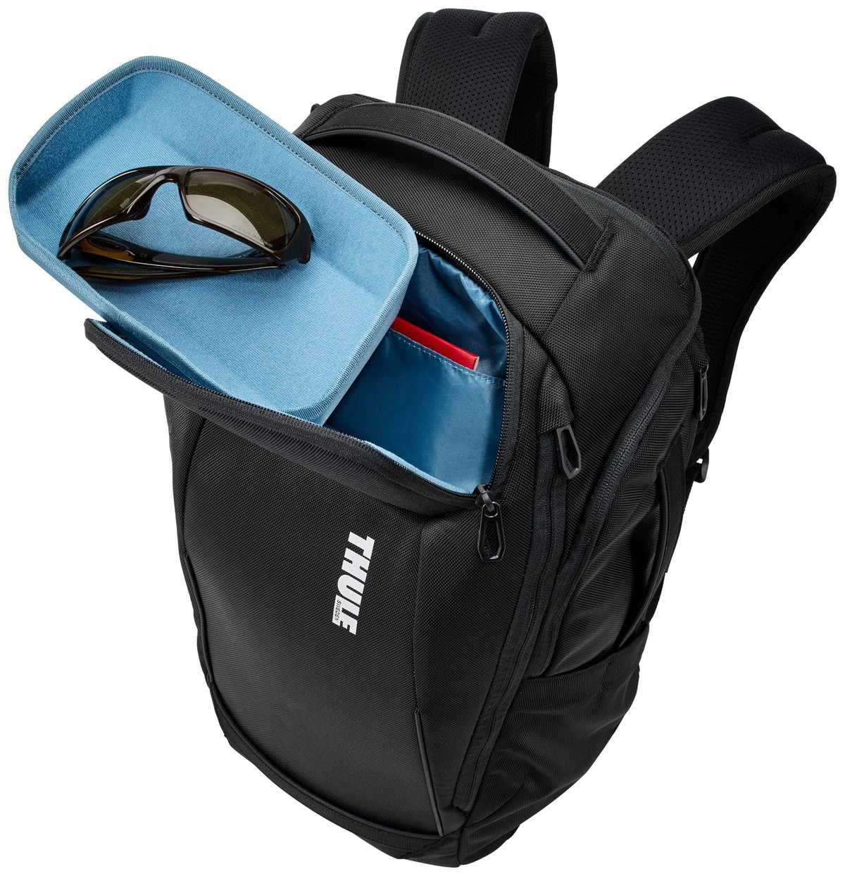 Schwarzer Thule-Rucksack mit offenem Fach, das Sonnenbrillen in einer blauen Hülle zeigt.