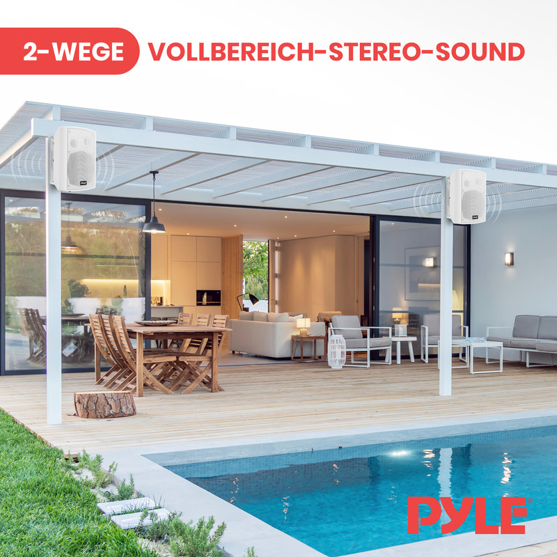 Weiße Lautsprecher an einer Pergola über einem Pool und Essbereich.
