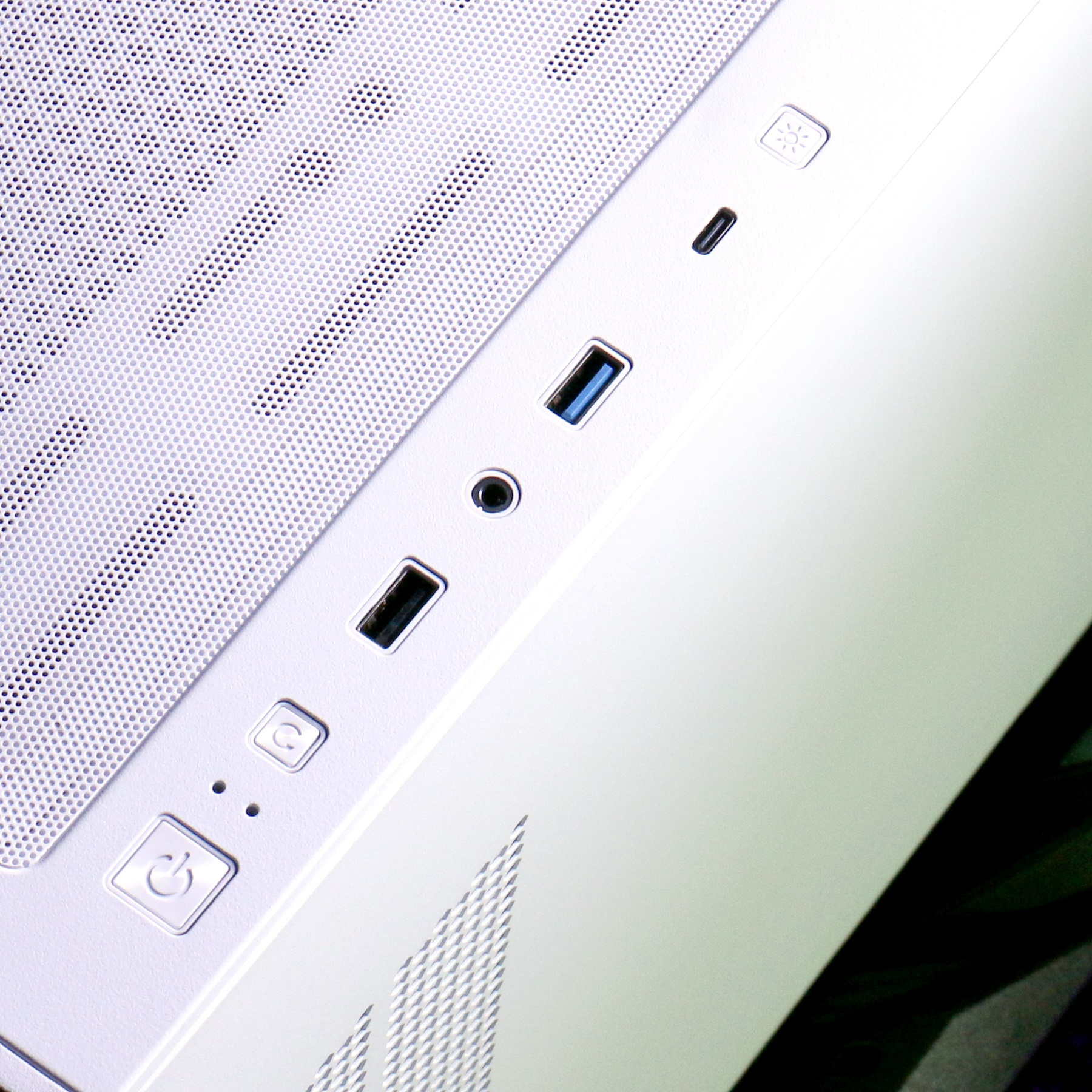 Weißes Computergehäuse mit Lüftungsgitter und Anschlüssen.