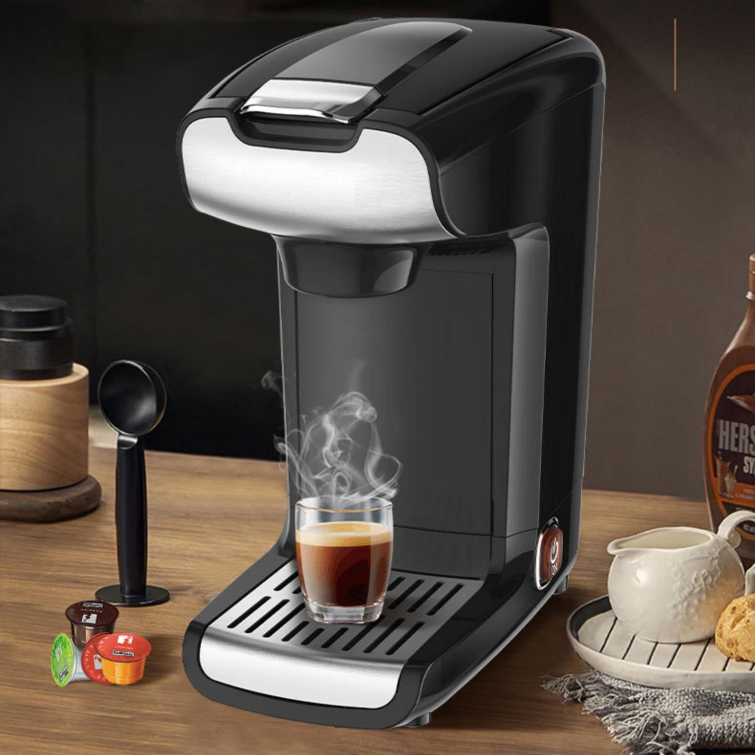 Ein schwarzer Kaffeekapselautomat brüht Espresso in ein Glas.