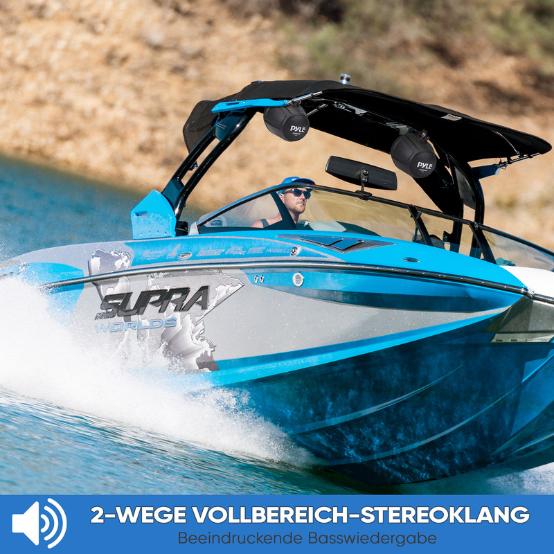Ein Mann fährt ein blaues Speedboot auf dem Wasser. Zwei Lautsprecher sind angebracht.