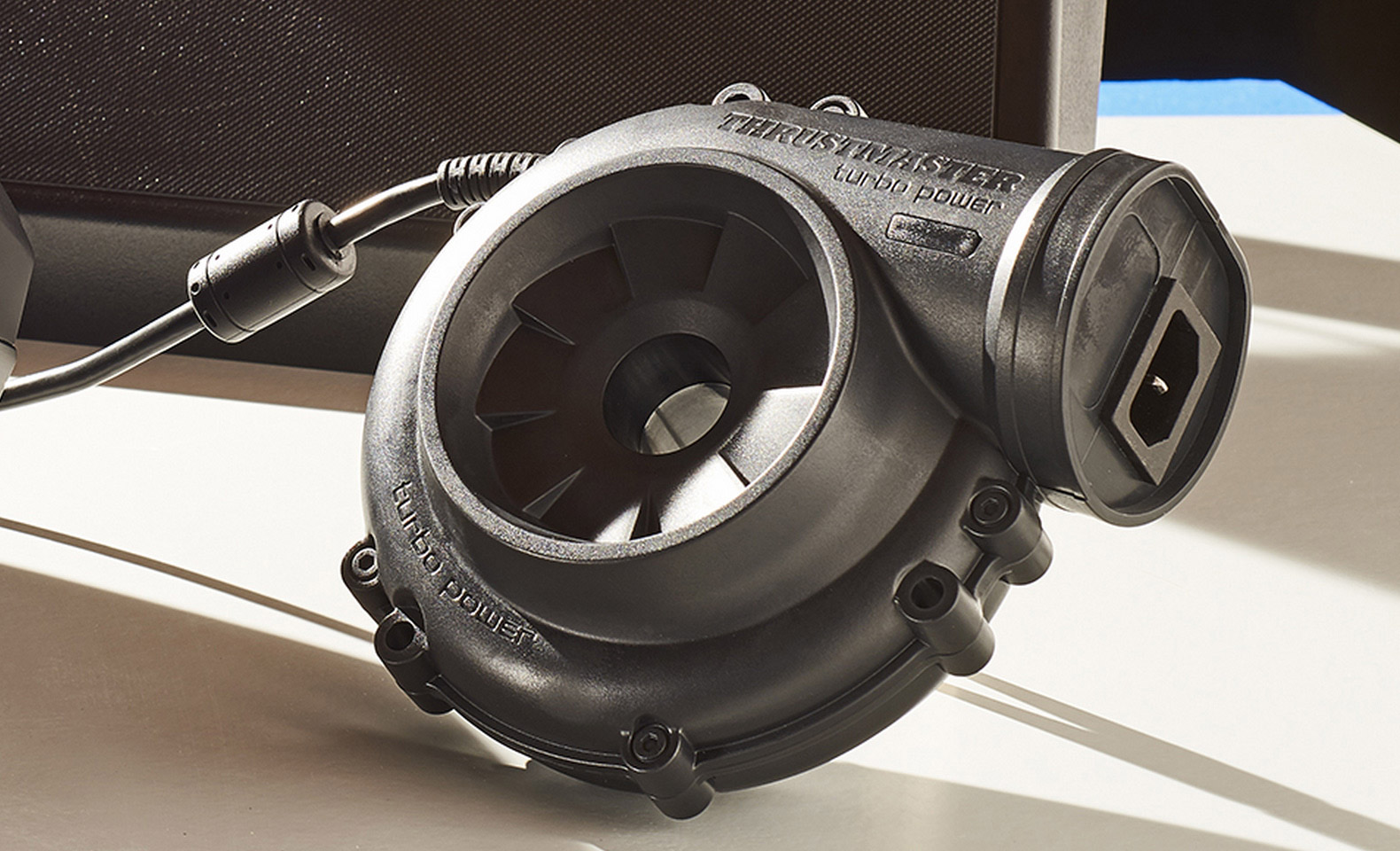 Un dispositivo Thrustmaster turbo power nero con superficie testurizzata e cavo.